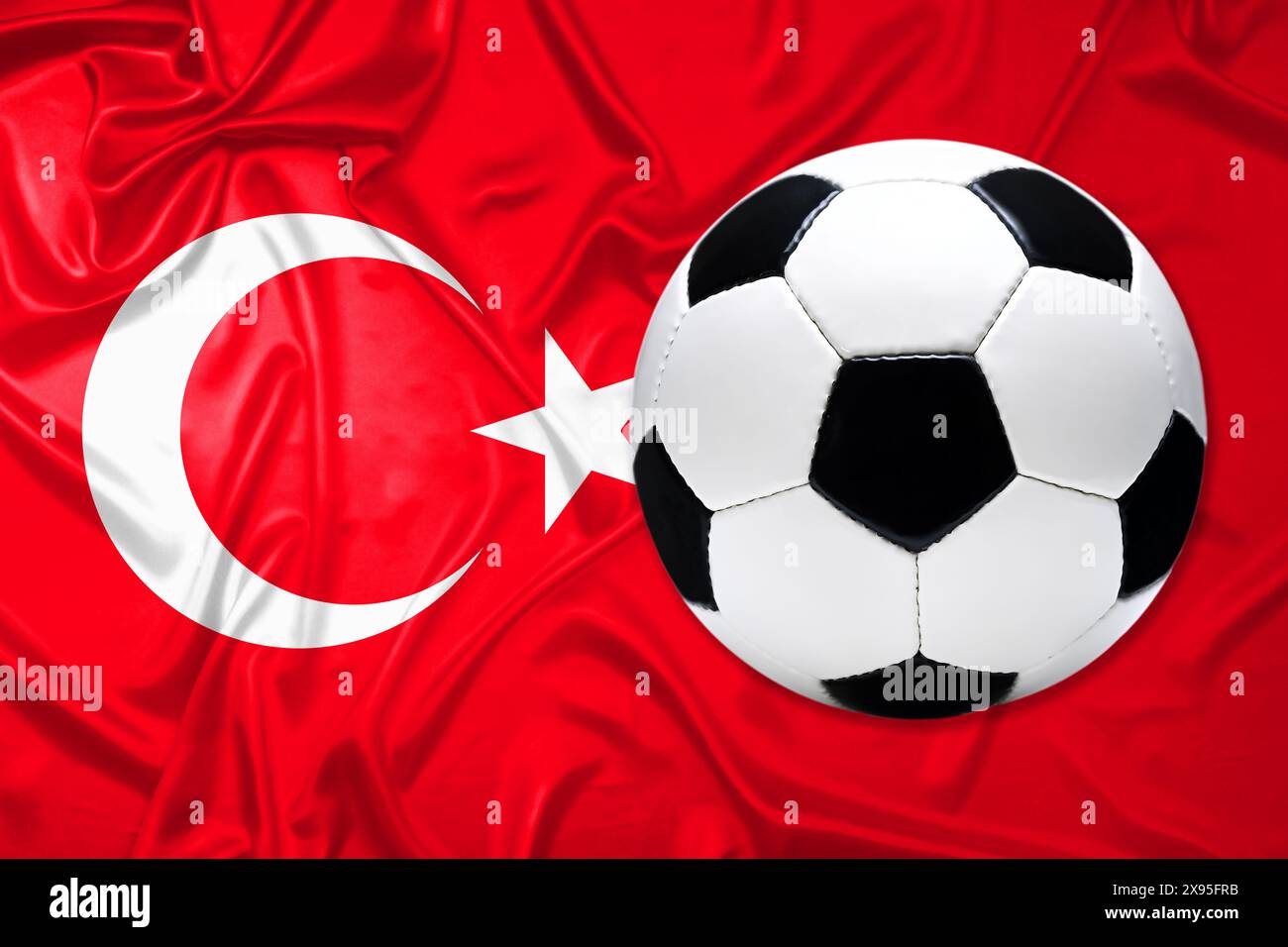 FOTOMONTAGE, Schwarz-Weißer Lederfußball mit Fahne von der Türkei Stock Photo
