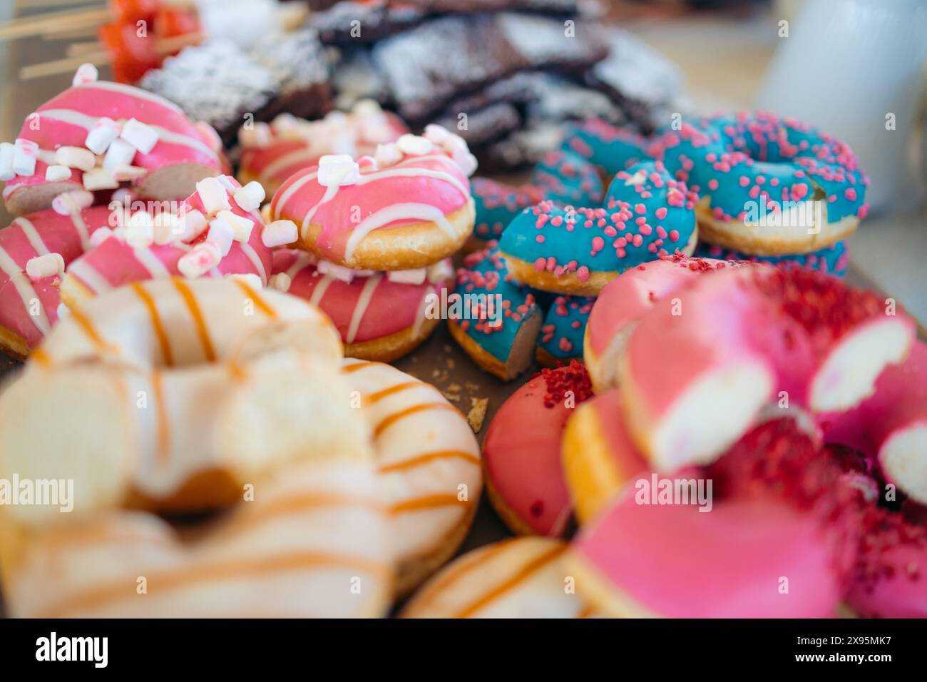 Closeup of a tray of donuts in different colours and with different ...