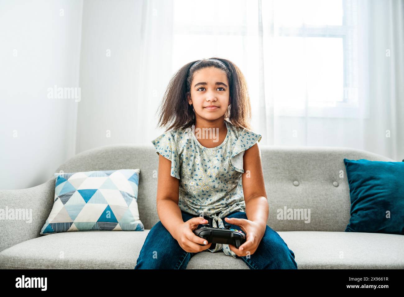 Young black woman using game controller to play video game Stock Photo