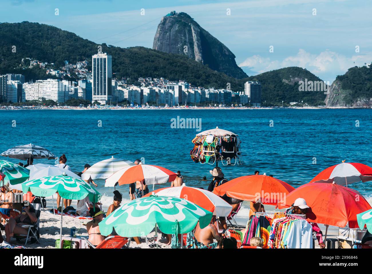 Man selling swimsuits at Copacabana Beach with iconic Sugarloaf ...