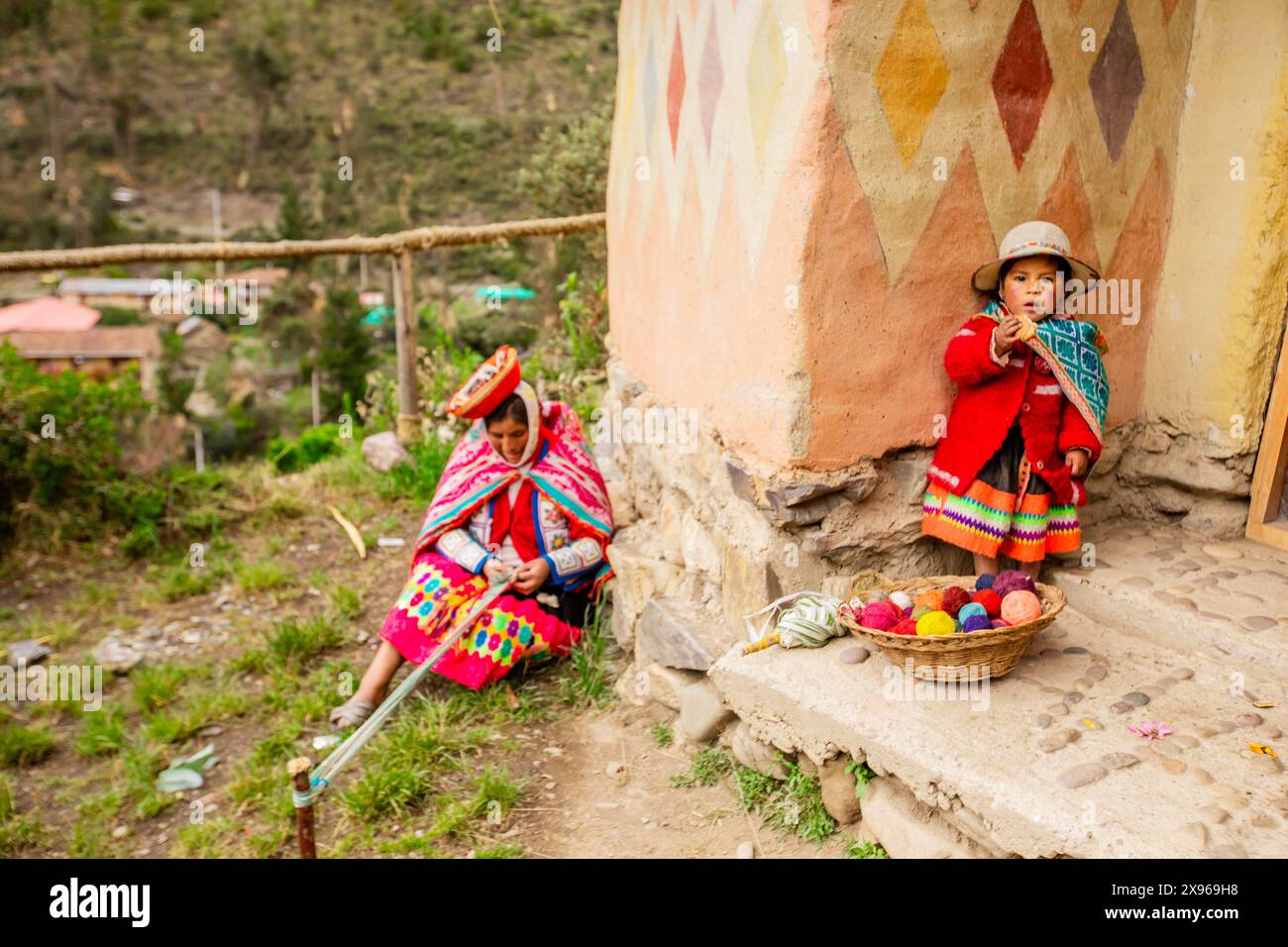 Quechua woman and child with snack, Ollantaytambo, Peru, South America Stock Photo