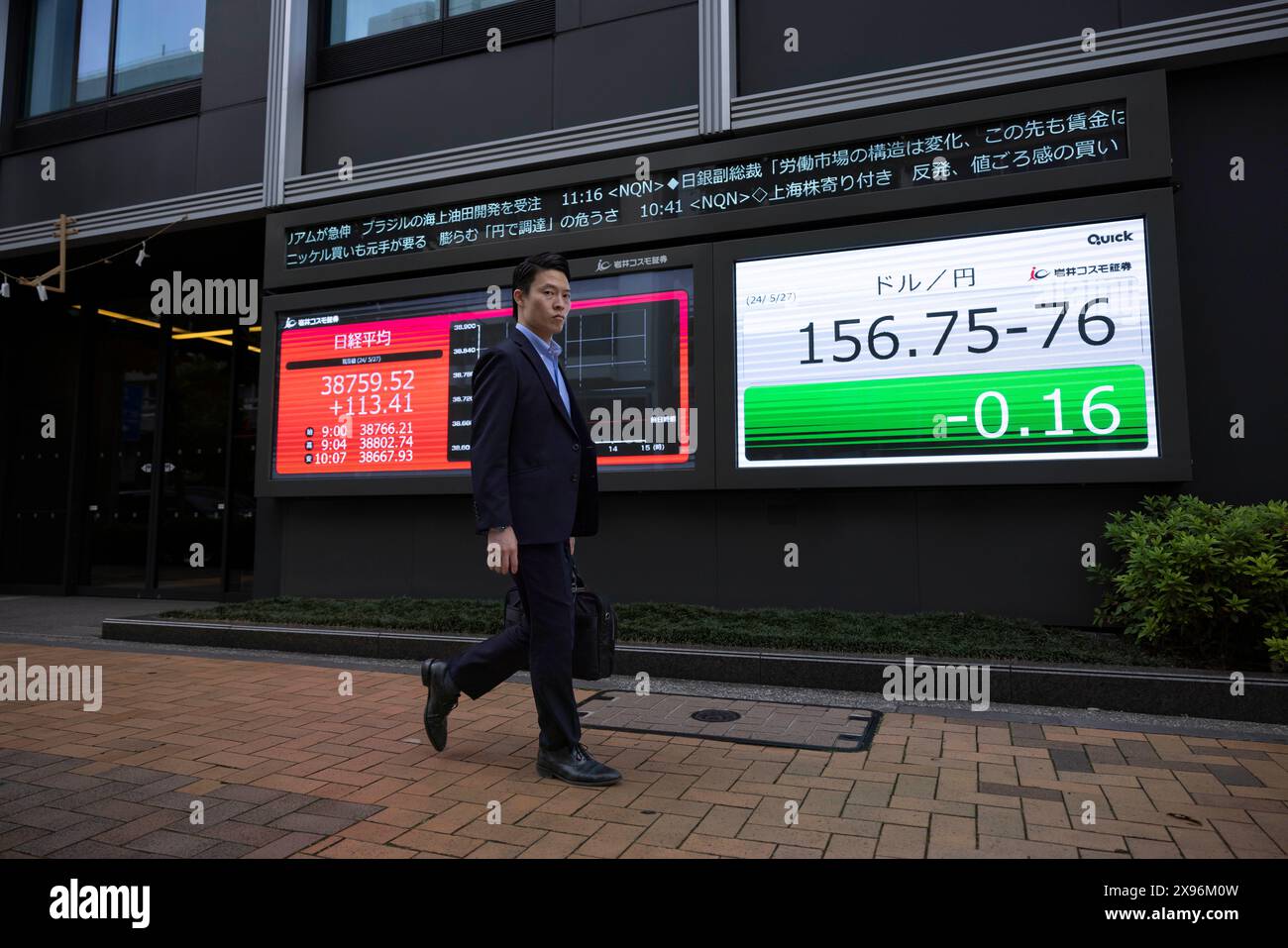 Man walks past a live view of nikkei 225 index Stock Photo Alamy