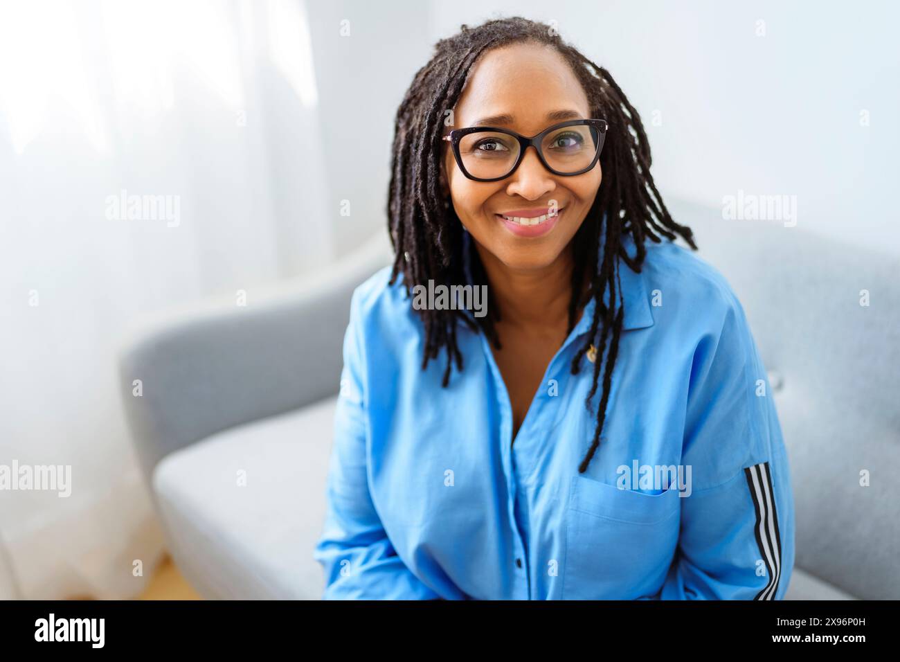 Portrait of an african woman sit on the sofa Stock Photo - Alamy