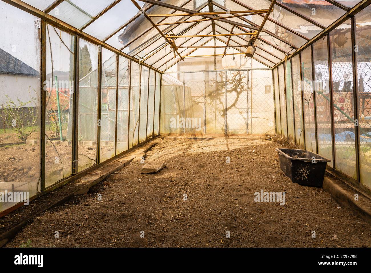 Inside of empty greenhouse, preparing soil in hothouse for sowing Stock Photo