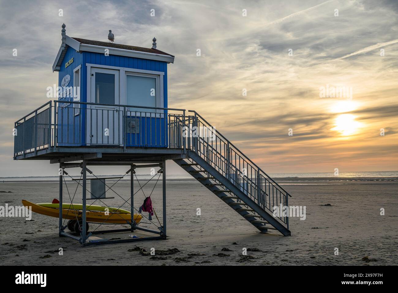A blue and white rescue tower with a secured boat next to it, in front ...