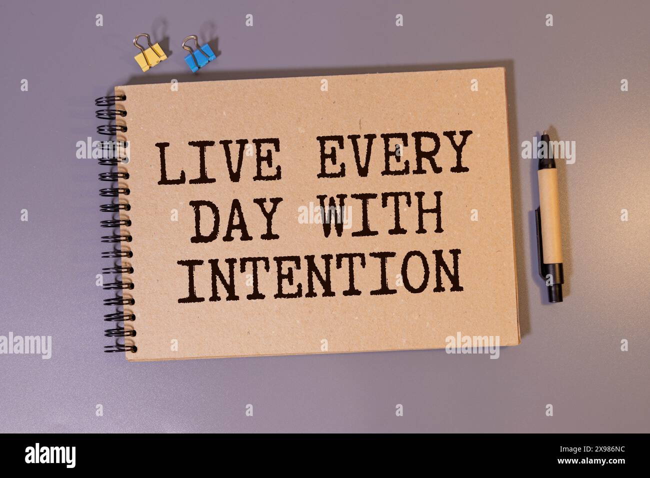Live every day with intention. Words written under torn paper ...