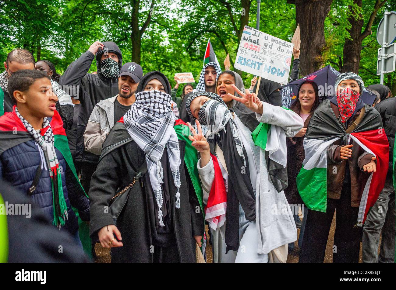 Two Palestinian female supporters wearing a Keffiyeh a symbol of Palestinian nationalism give a peace sign, during today's 'Hands of Rafah' demonstration in The Hague. A few hundred pro-Palestinian protesters stood opposite the 'Tweede Karmer' or, the 'Second Chamber' the Dutch seat of government in The Hague, during todayís 'Hands off Rafah - Where is your red line Rutte?'. The demonstrators stood in pouring rain, some with megaphones, and demanding the Dutch government change its stance in its support of Israel. The demonstration was in response to Rafah on Sunday, in which 45 people were ki Stock Photo