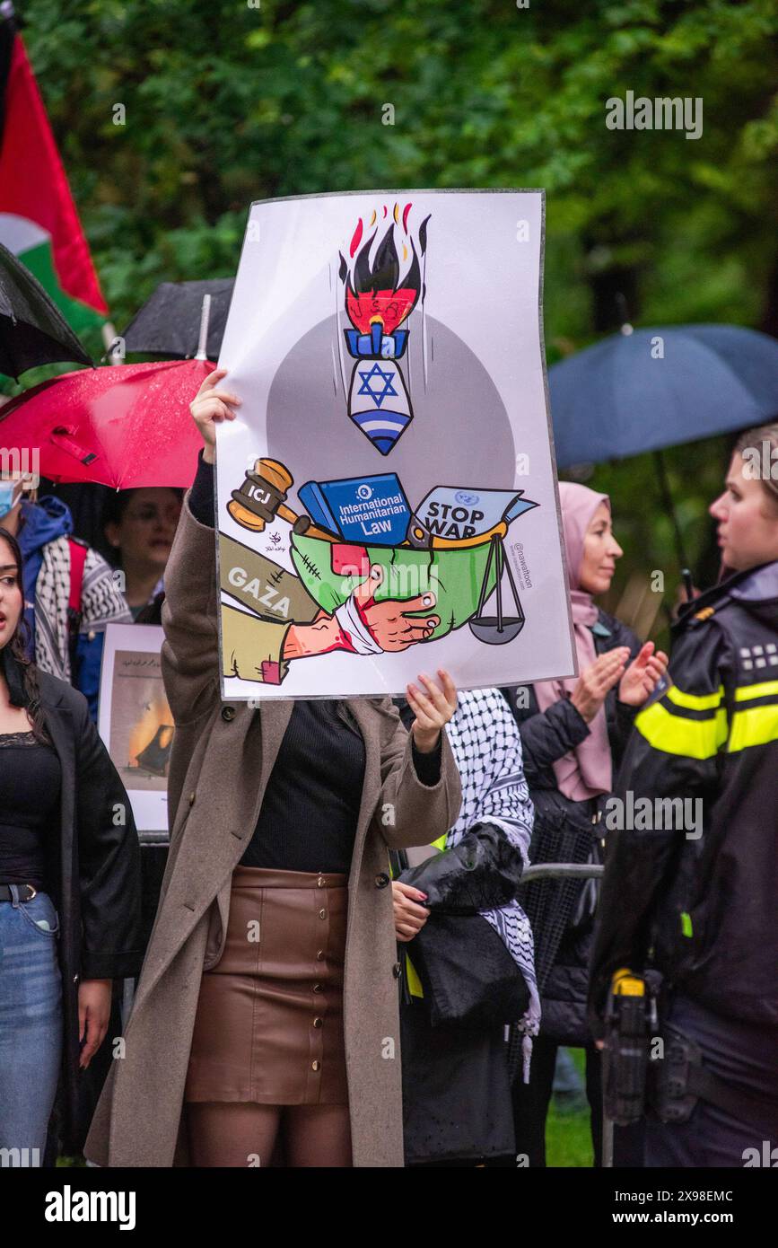 Pro-Palestinian female supporter holding a poster and expressing her opinion, during today's 'Hands of Rafah' demonstration in The Hague. A few hundred pro-Palestinian protesters stood opposite the 'Tweede Karmer' or, the 'Second Chamber' the Dutch seat of government in The Hague, during todayís 'Hands off Rafah - Where is your red line Rutte?'. The demonstrators stood in pouring rain, some with megaphones, and demanding the Dutch government change its stance in its support of Israel. The demonstration was in response to Rafah on Sunday, in which 45 people were killed, according to the Humas-r Stock Photo