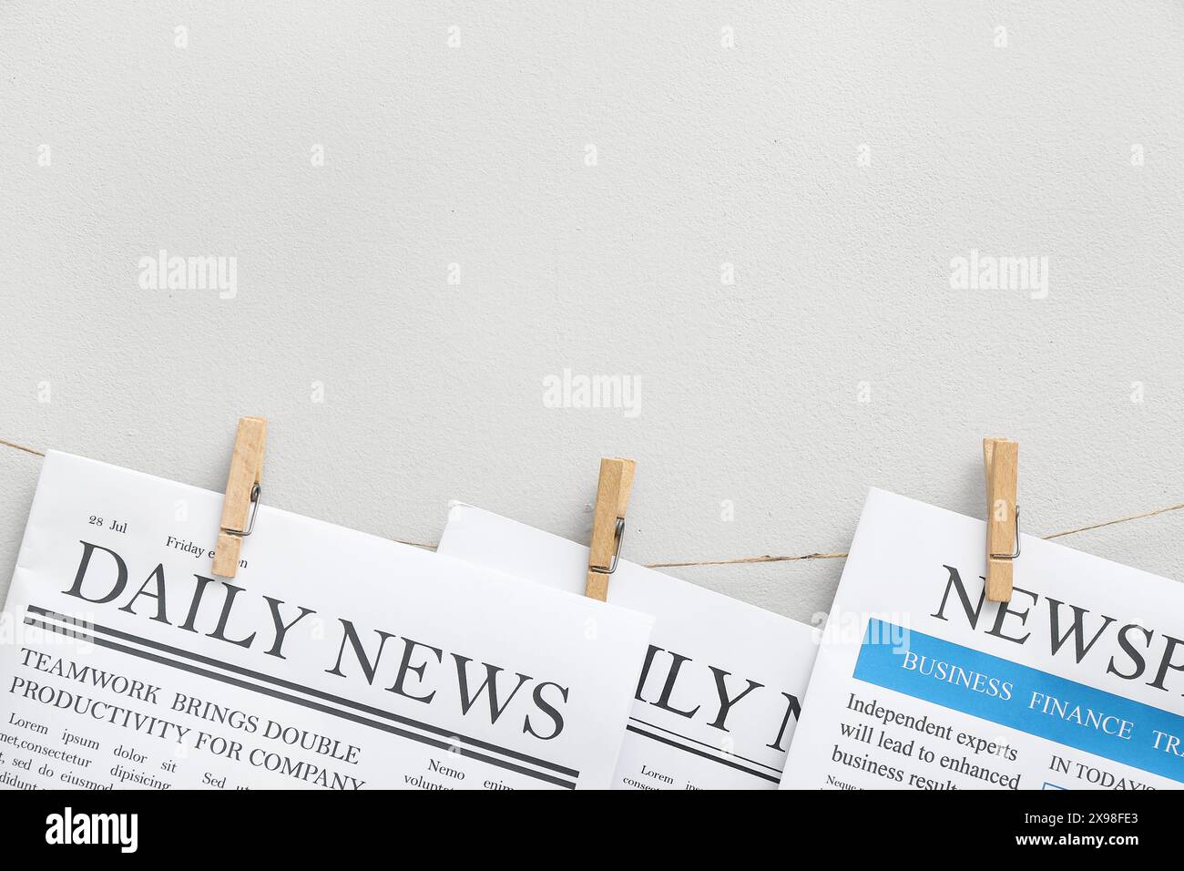Newspaper Rope Newspapers hanging on rope against white background Stock Photo - Alamy