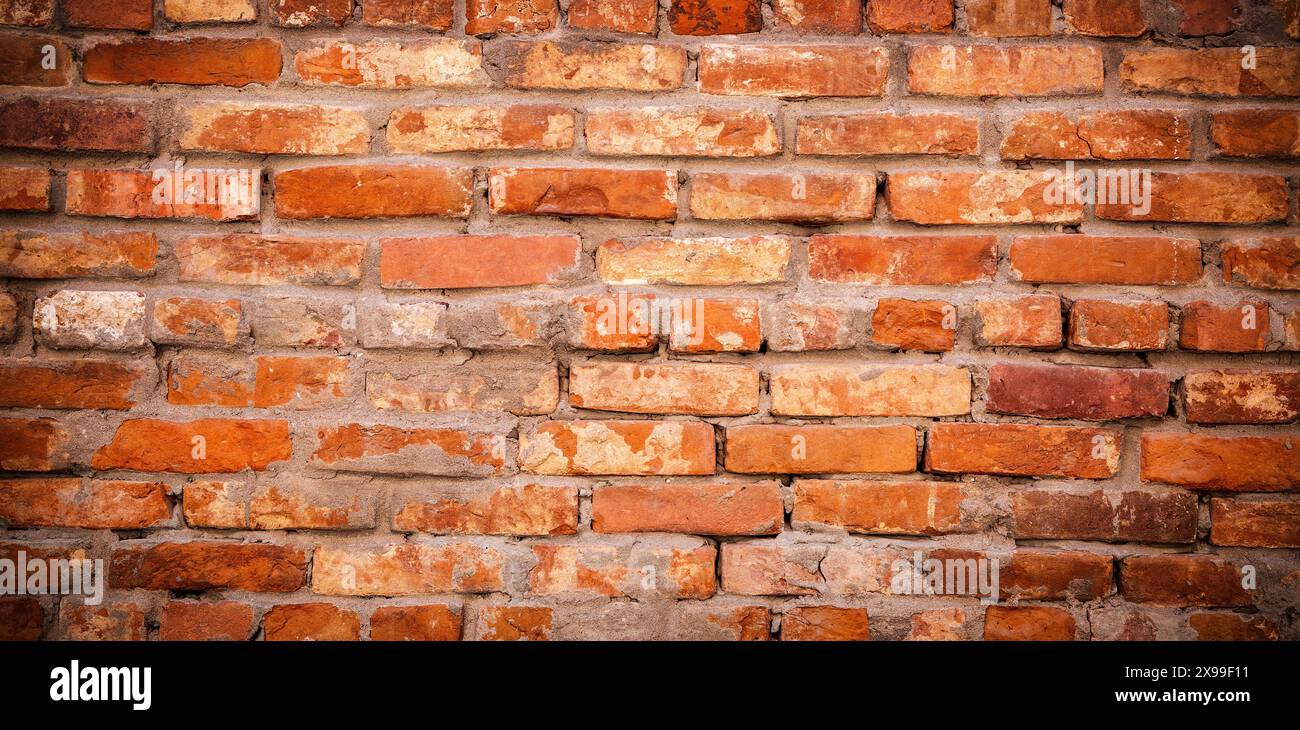 Old weathered red brick wall as creative background. Bricks masonry with seams Stock Photo