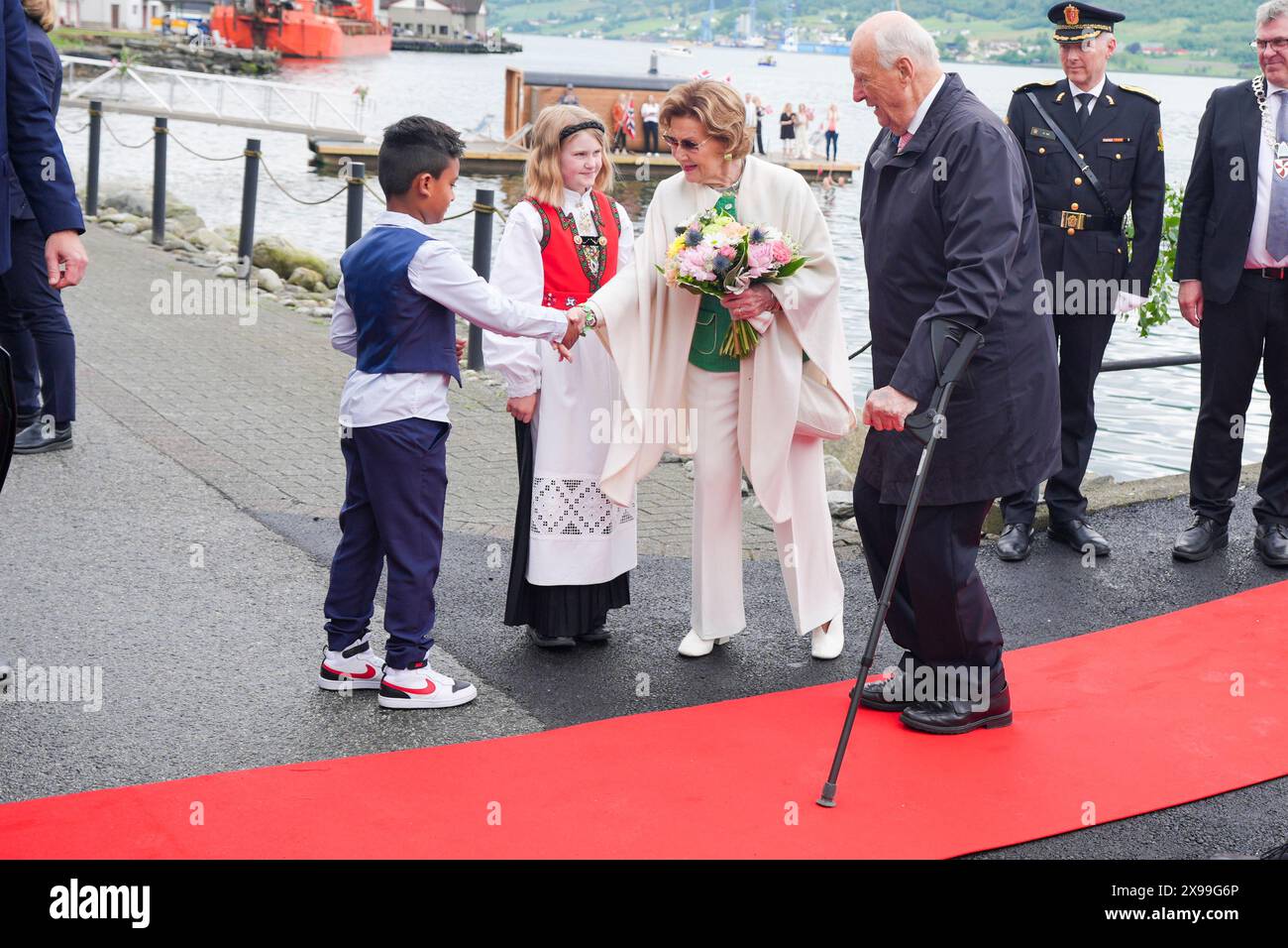 Olen in Vindafjord 20240530. Aarib Aegir Khan (8) and Elina Kambe Johannson (10) welcome King Harald and Queen Sonja with flowers when they visit Ølen in Vindafjord municipality in Rogaland in connection with the county visits to Agder and Rogaland 26-30 May. Photo: Lise Åserud / NTB Stock Photo