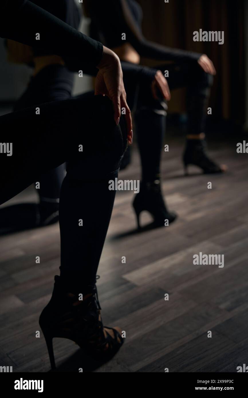 Three stiletto dancers doing floorwork choreography in studio Stock Photo