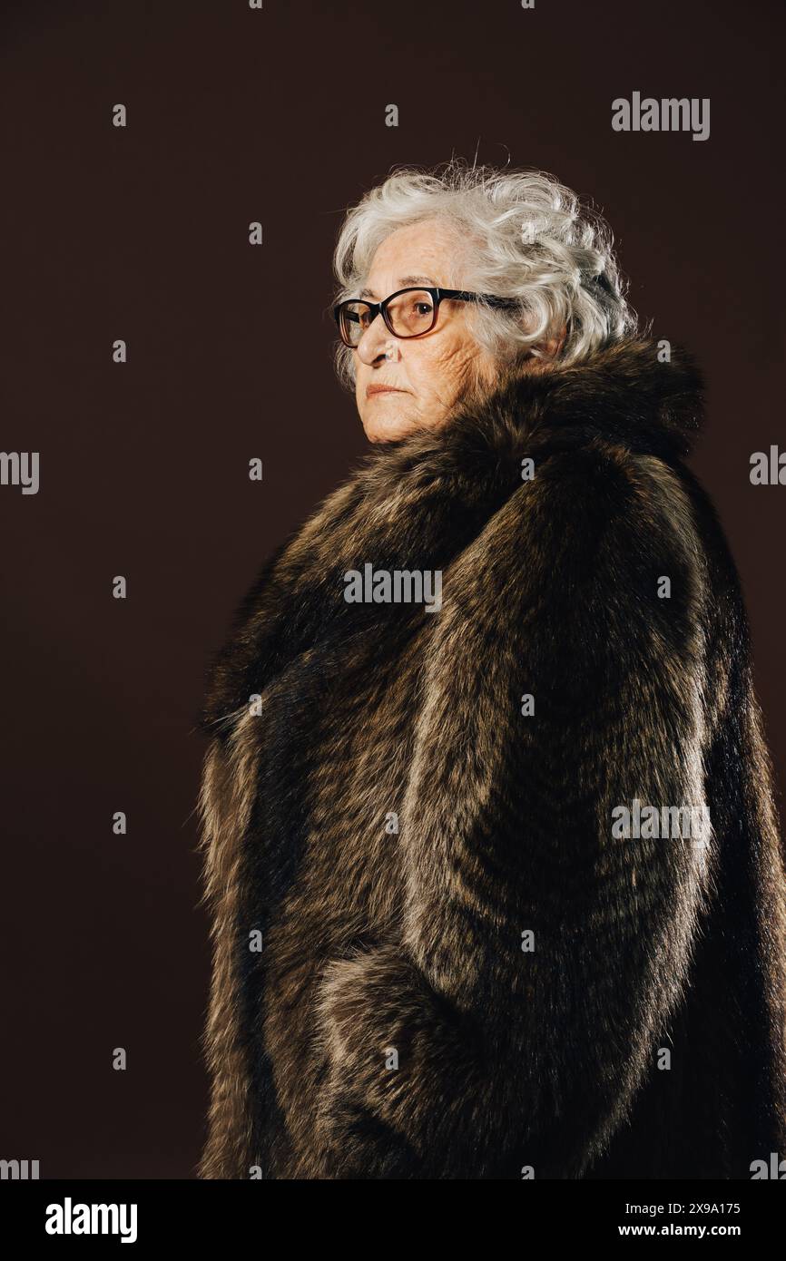 Studio shoot of a serious elderly woman with curly white hair and ...