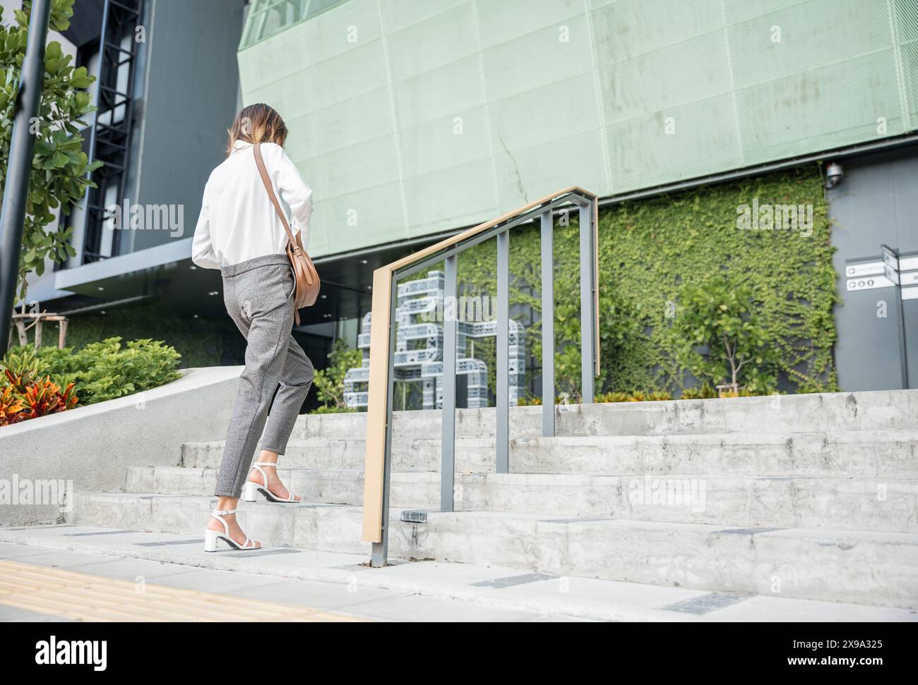 Woman running up stairs suit hi-res stock photography and images - Alamy
