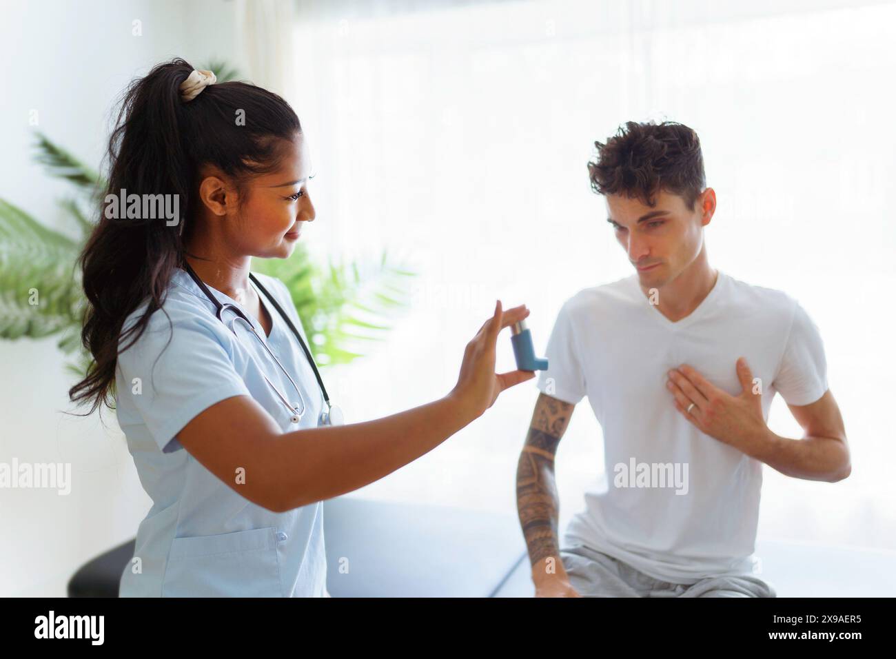 man using inhaler during asthmatic attack with doctor Stock Photo