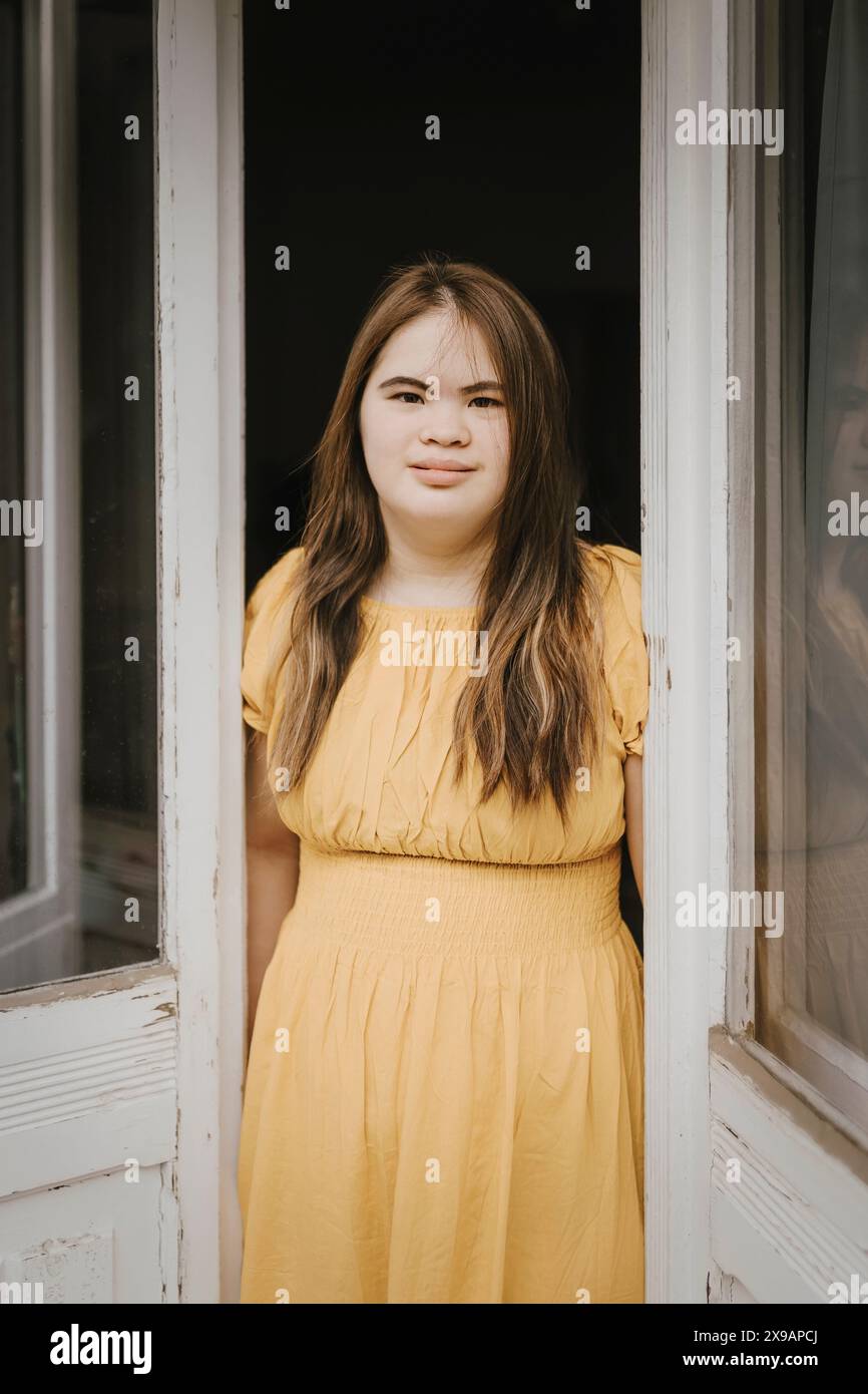 Portrait of young woman with down syndrome standing at doorway Stock ...