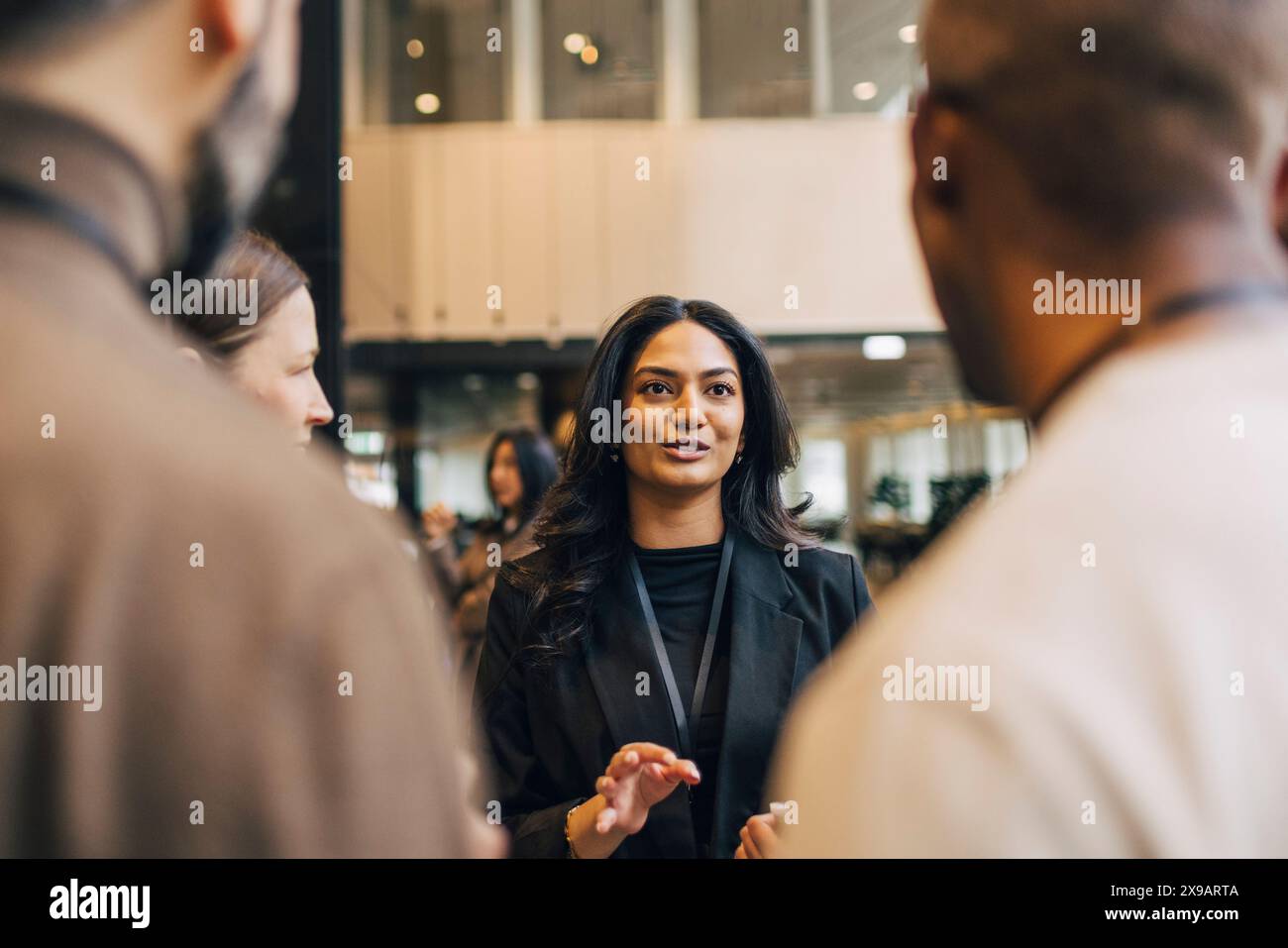 Young Female Entrepreneur Discussing With Delegates During Networking