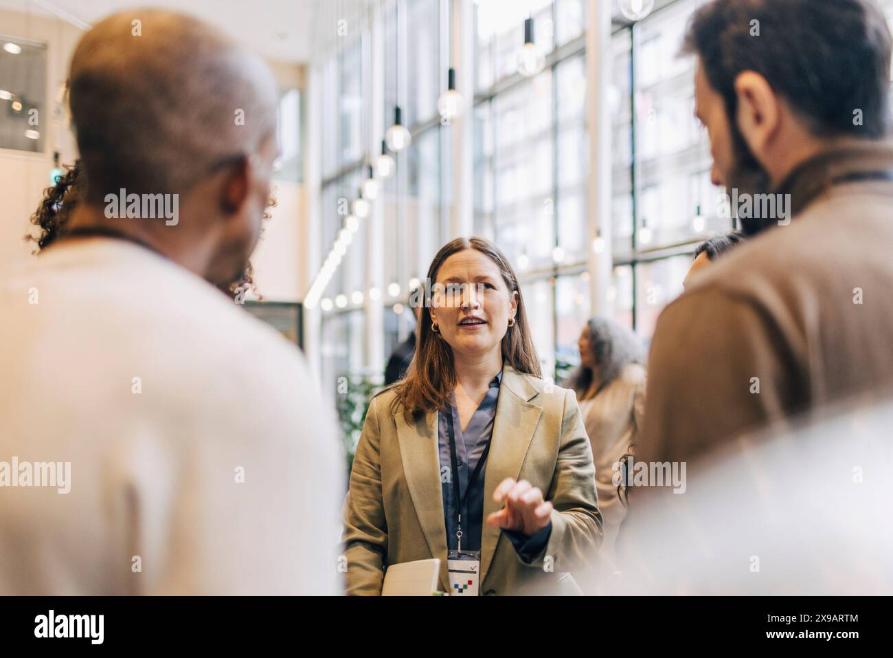 Female Entrepreneur Explaining While Standing With Delegates During