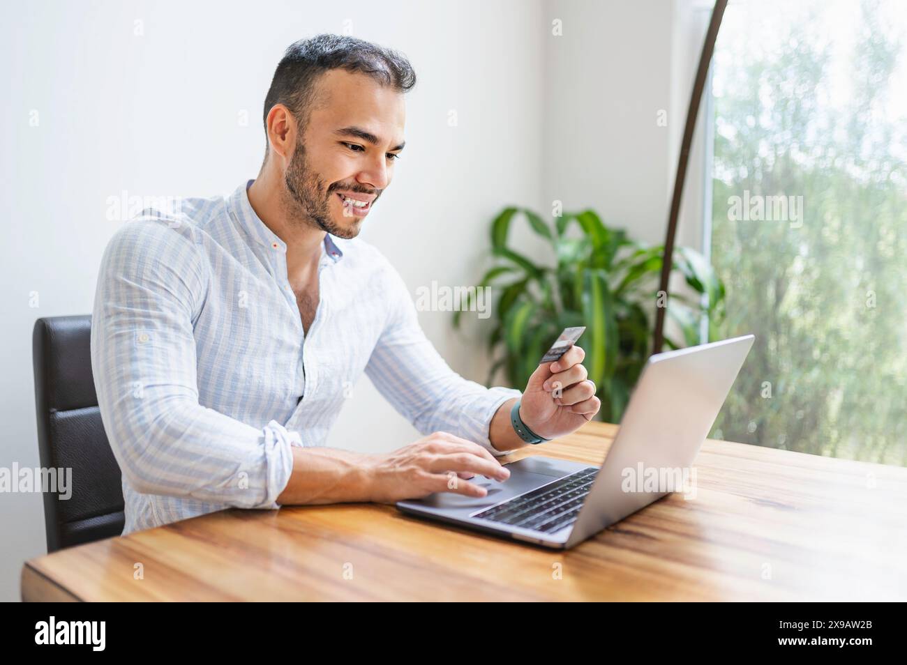 Portrait young mexican attractive businessman working at modern home office with computer laptop Stock Photo