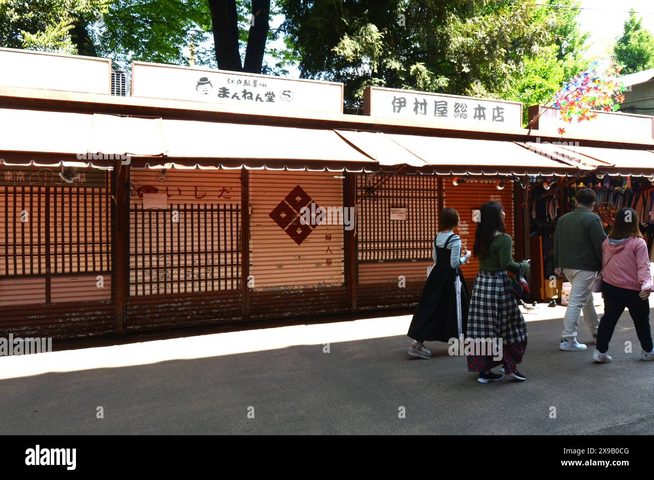 Japan Japanese people person Tokyo street streets place local shop shops lottery shop scouts scout shopping ice cream eating food drinks carpets rug Stock Photo