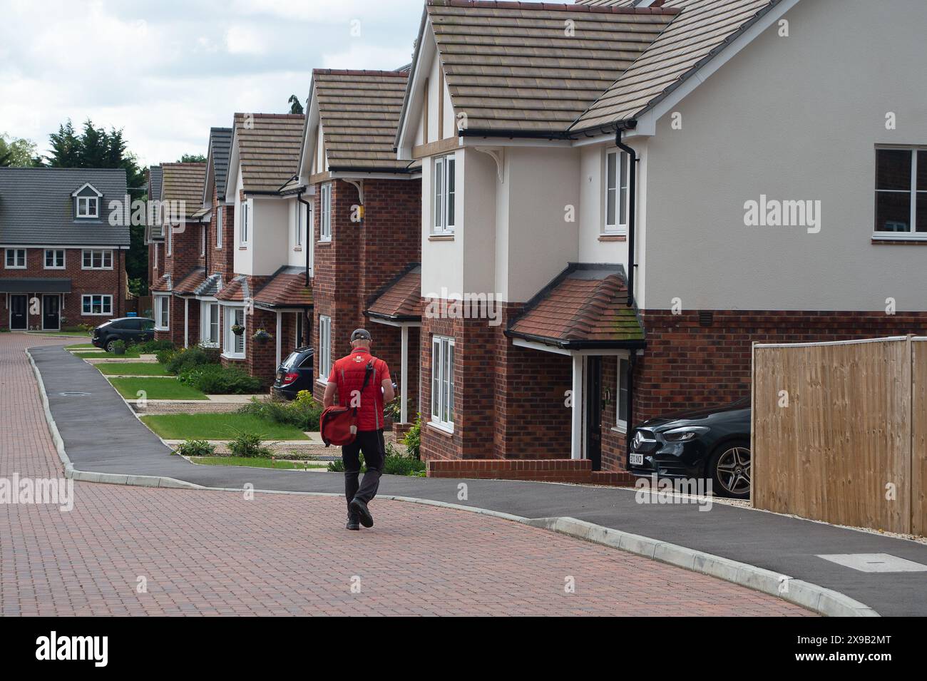 Maidenhead, UK. 30th May, 2024. A postal worker delivering mail to