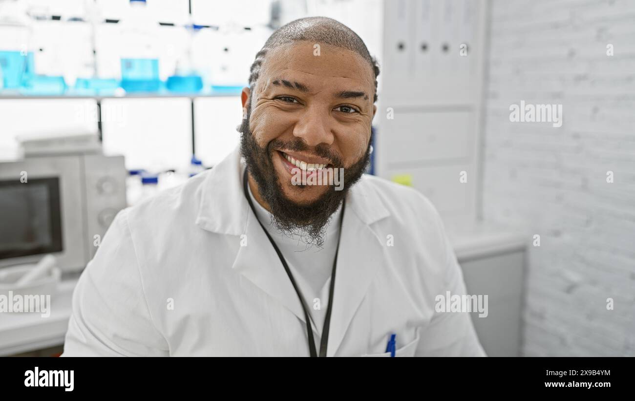 Smiling african american male scientist in a white lab coat inside a ...