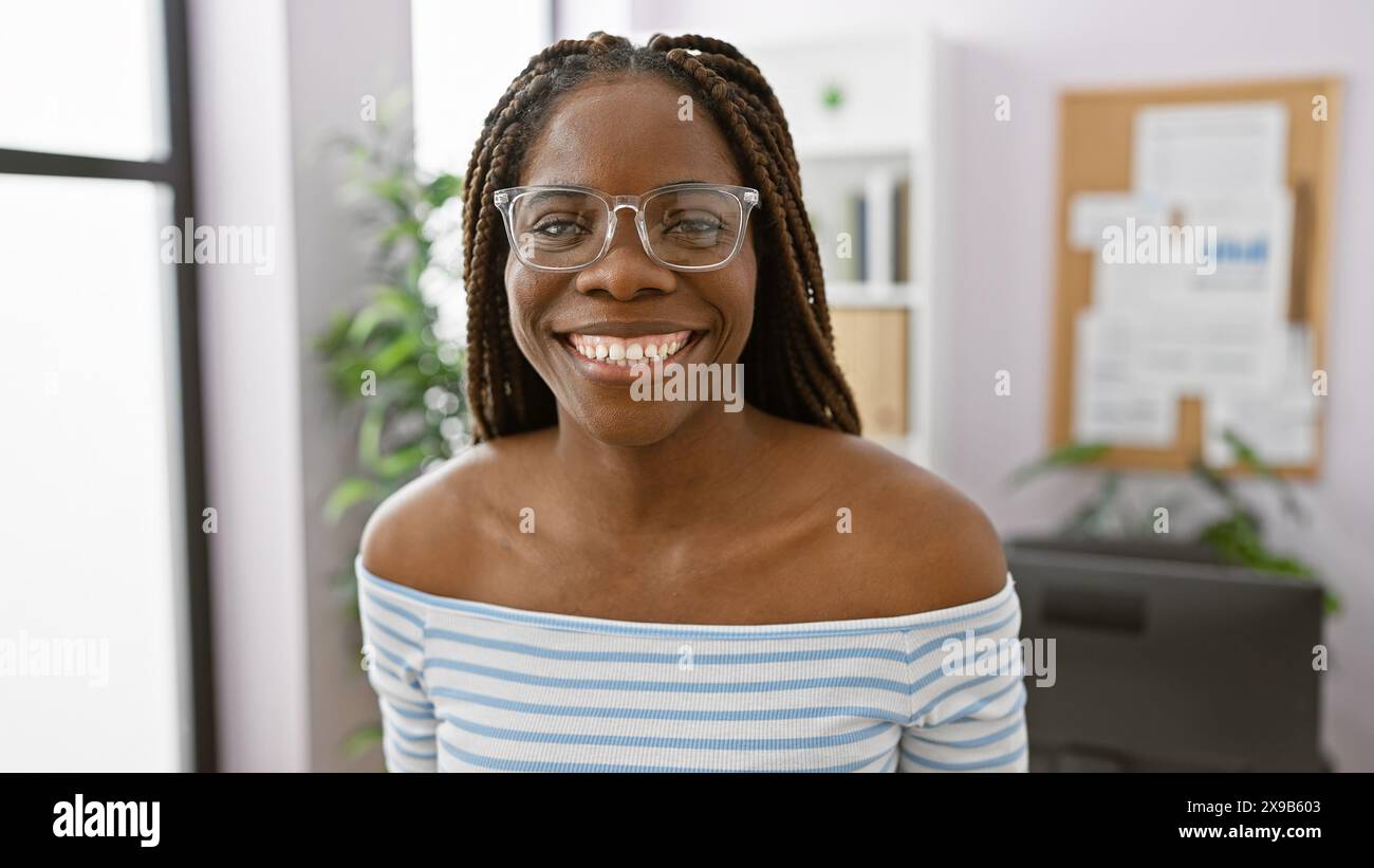 Smiling african american woman with braids wearing glasses in a bright ...