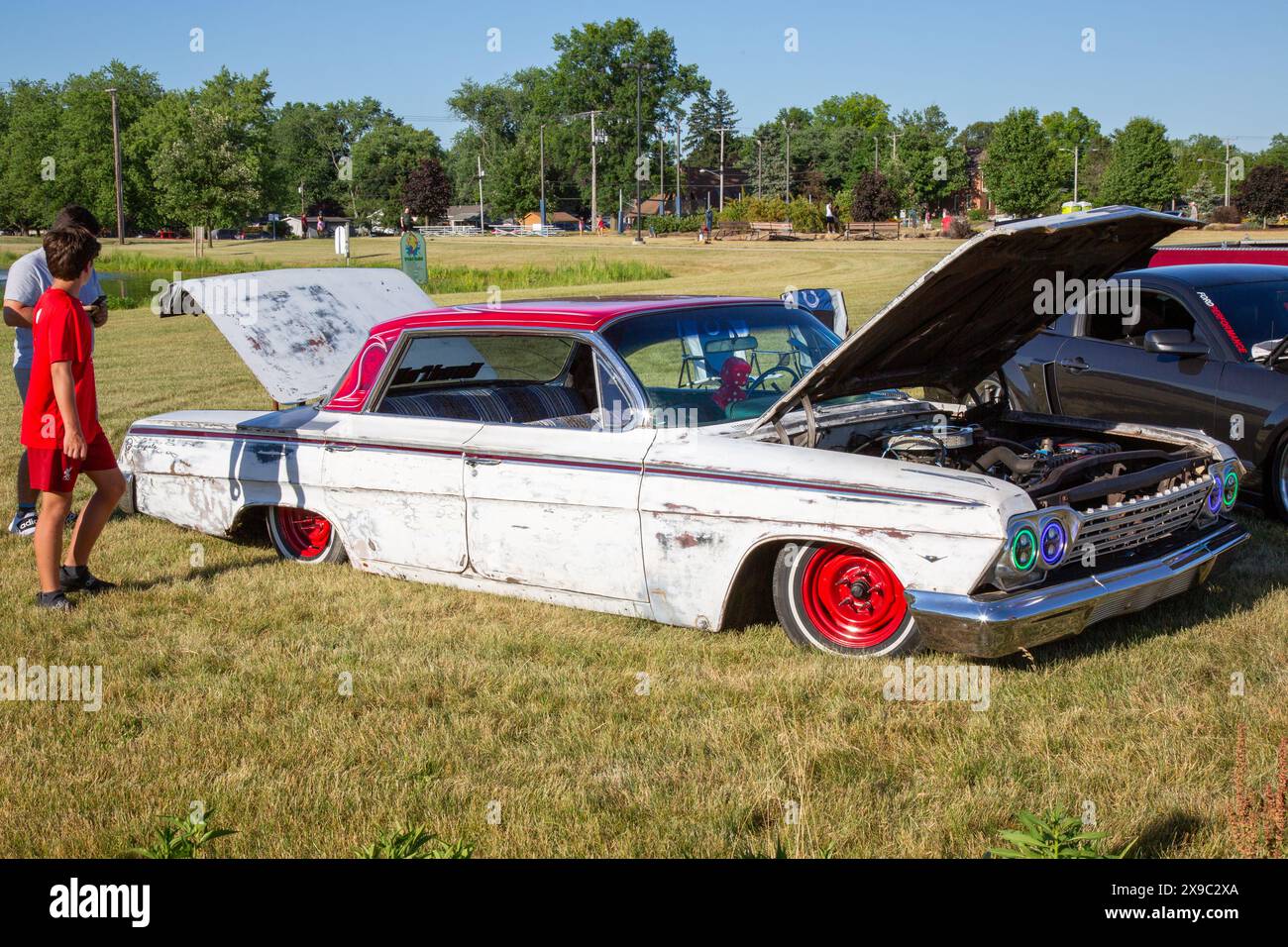 A white and red 1962 Chevrolet Impala lowrider on display in a car show at Riverside Gardens Park in Leo-Cedarville, Indiana, USA. Stock Photo