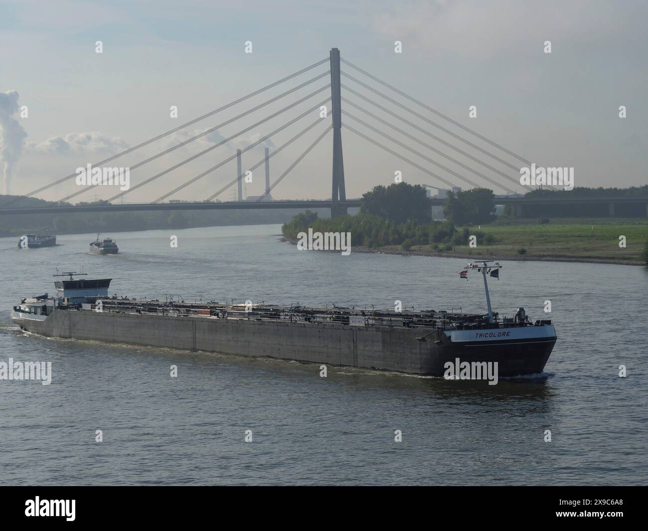 Novigating Bridge Cargo ship navigating the river under a prominent bridge, industry in ...