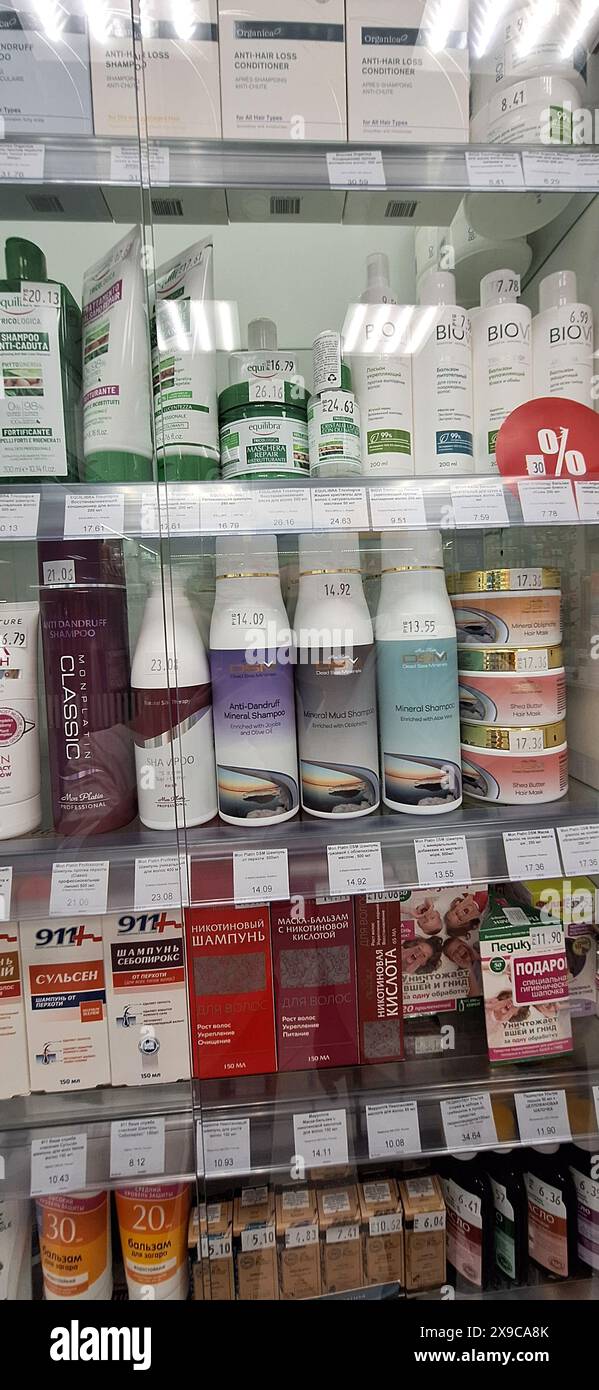 Bobruisk, Belarus - May 1, 2024: A local pharmacy display case showcasing an array of hair masks, shampoos, conditioners, balms, and sun creams on a w Stock Photo