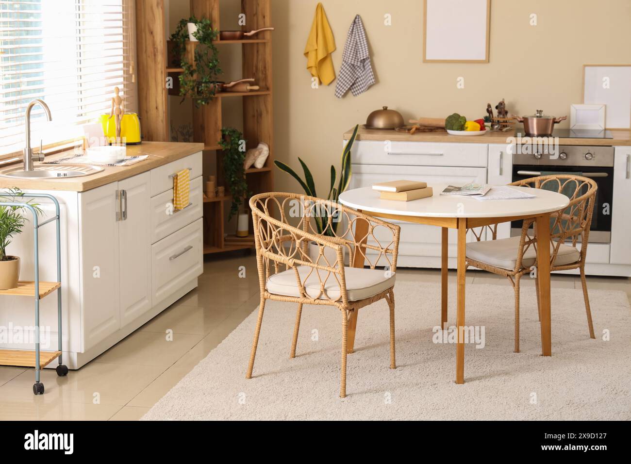 Interior of modern kitchen with dining table, white counters and blank ...