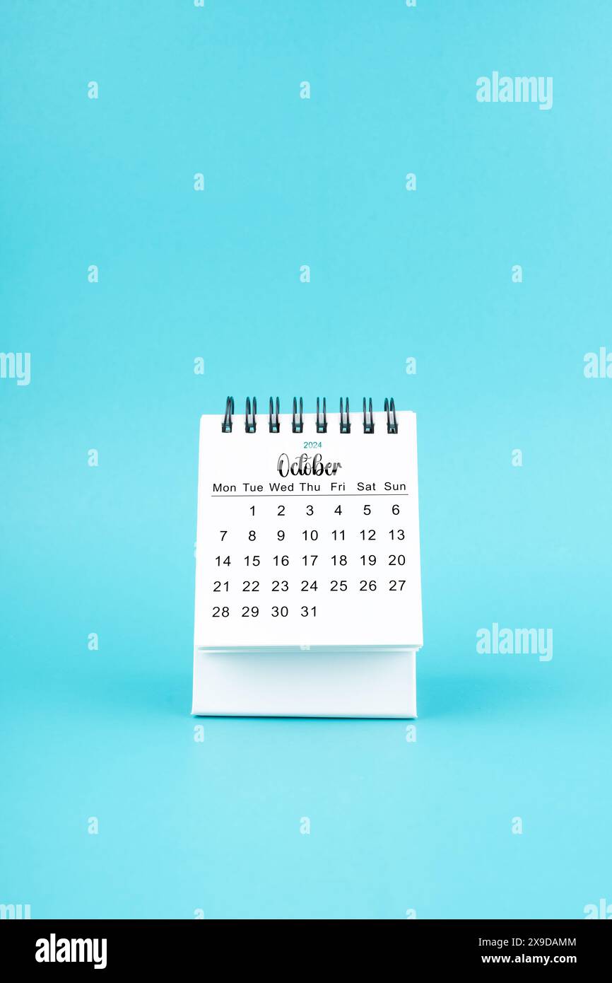 October 2024 white desk calendar on blue color background Stock Photo ...