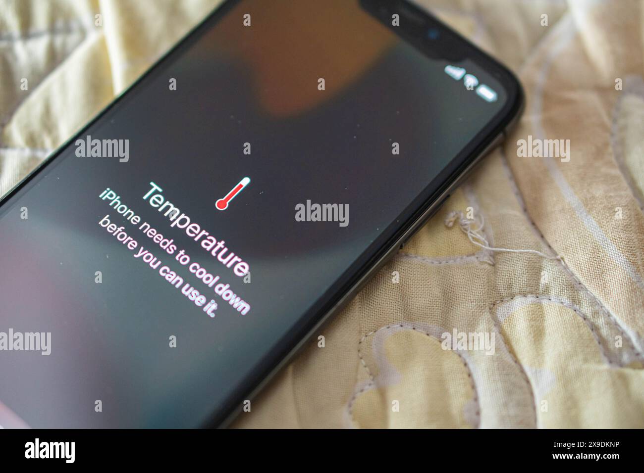 A smartphone displaying a temperature warning message indicating that