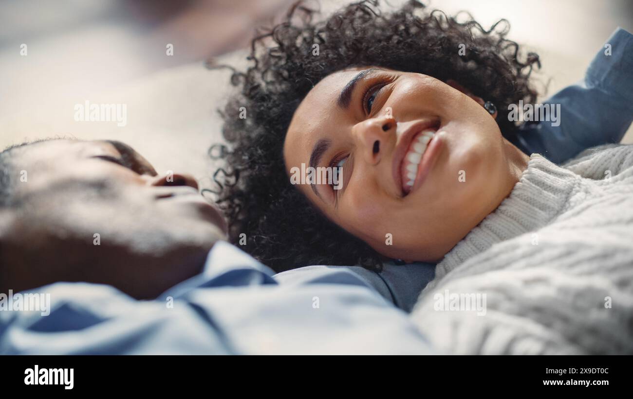Young Happy Smiling Black Couple Is Laying on the Floor and Enjoying an