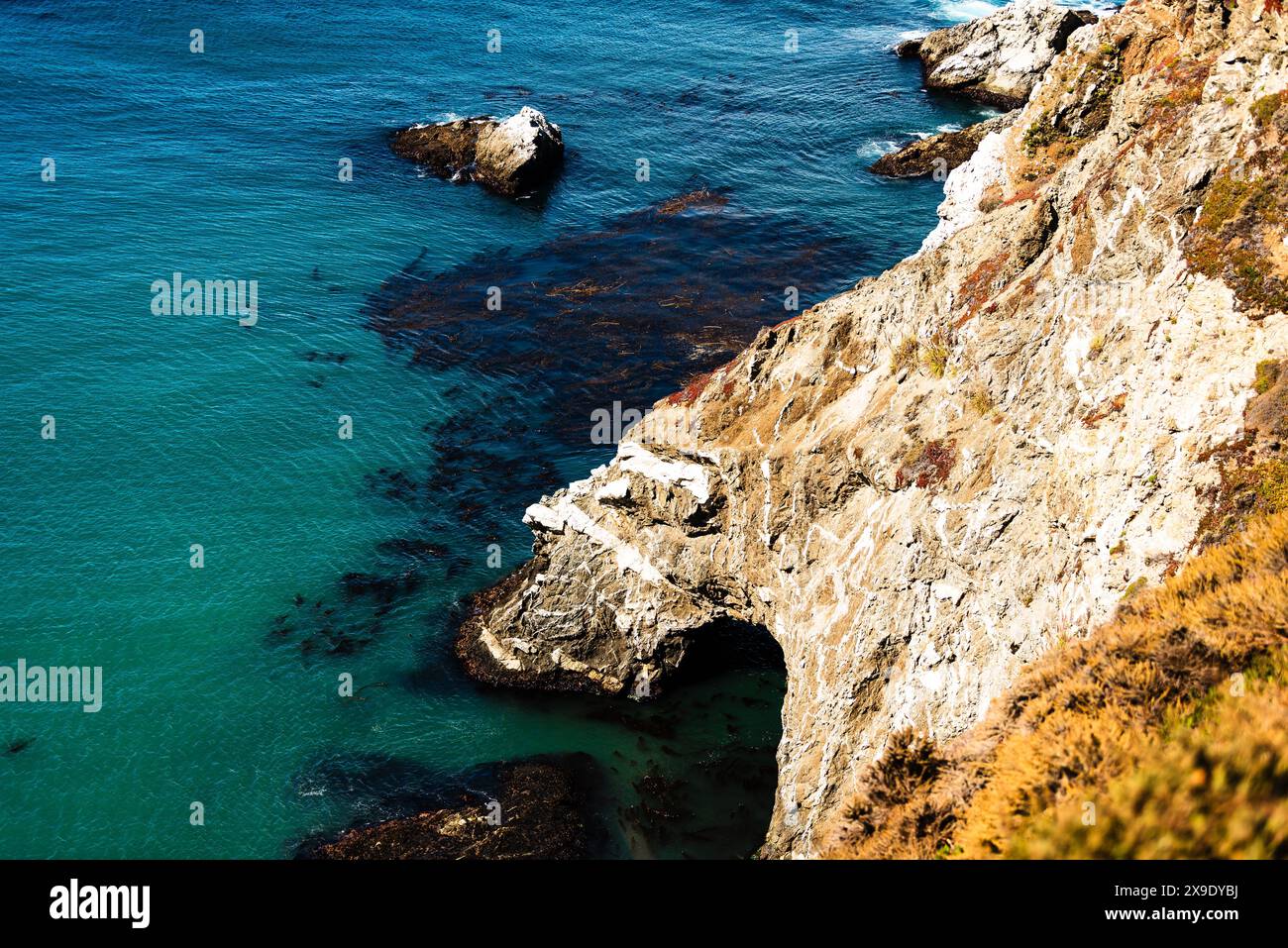 Scenic coastal cliff with turquoise water and rocky shoreline Stock ...