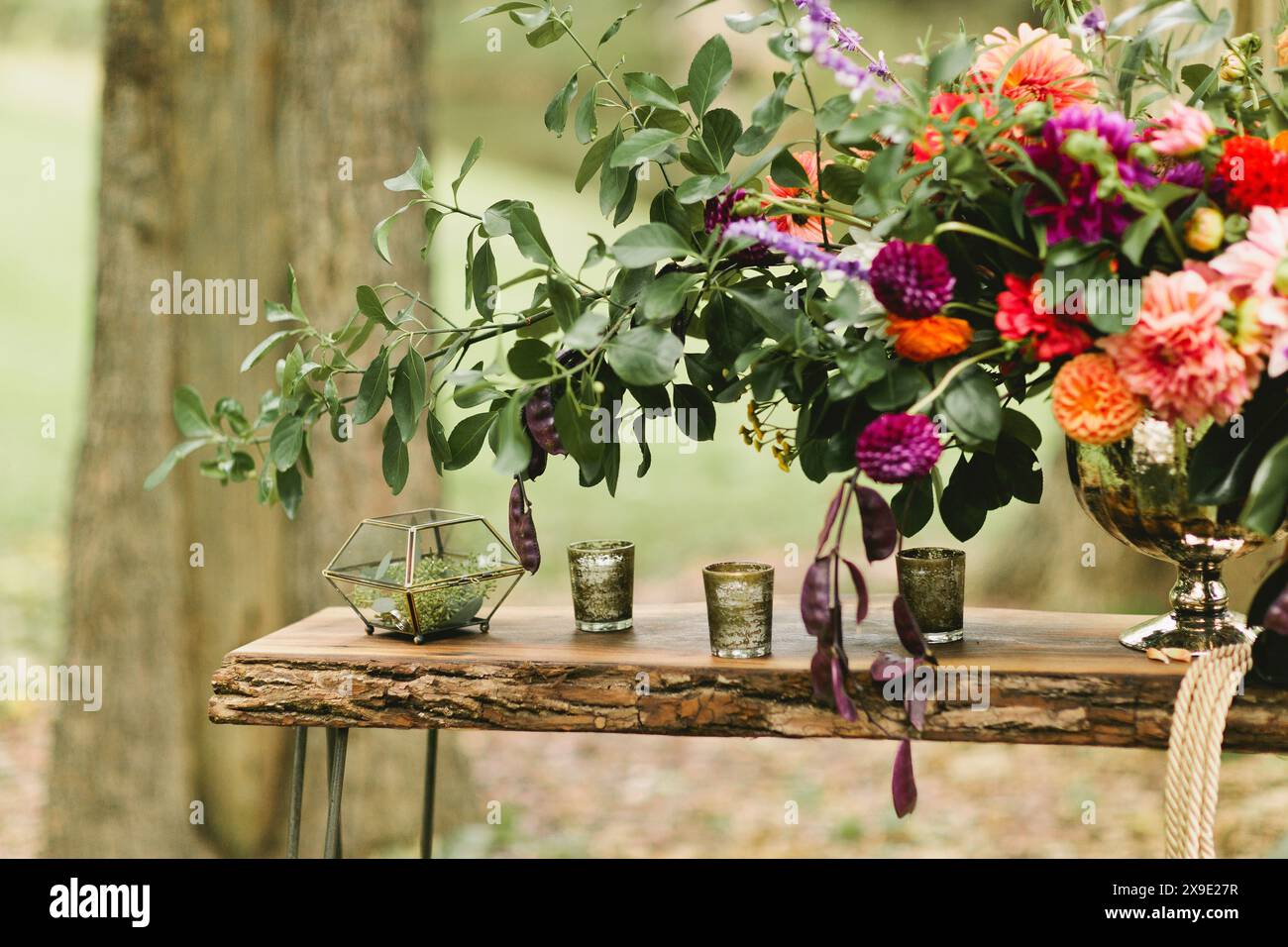 Flower arrangement sits on rustic wooden table Stock Photo