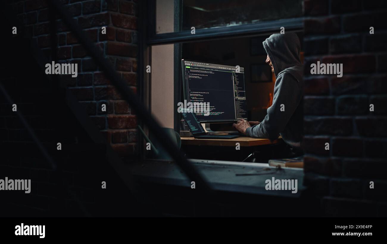 Single-Minded Professional Programmer Obsessively Writing a Code on His Desktop Computer, Late at Night. IT Specialist Ethical Hacker Working on Computer, Finding Software Vulnerabilities Stock Photo