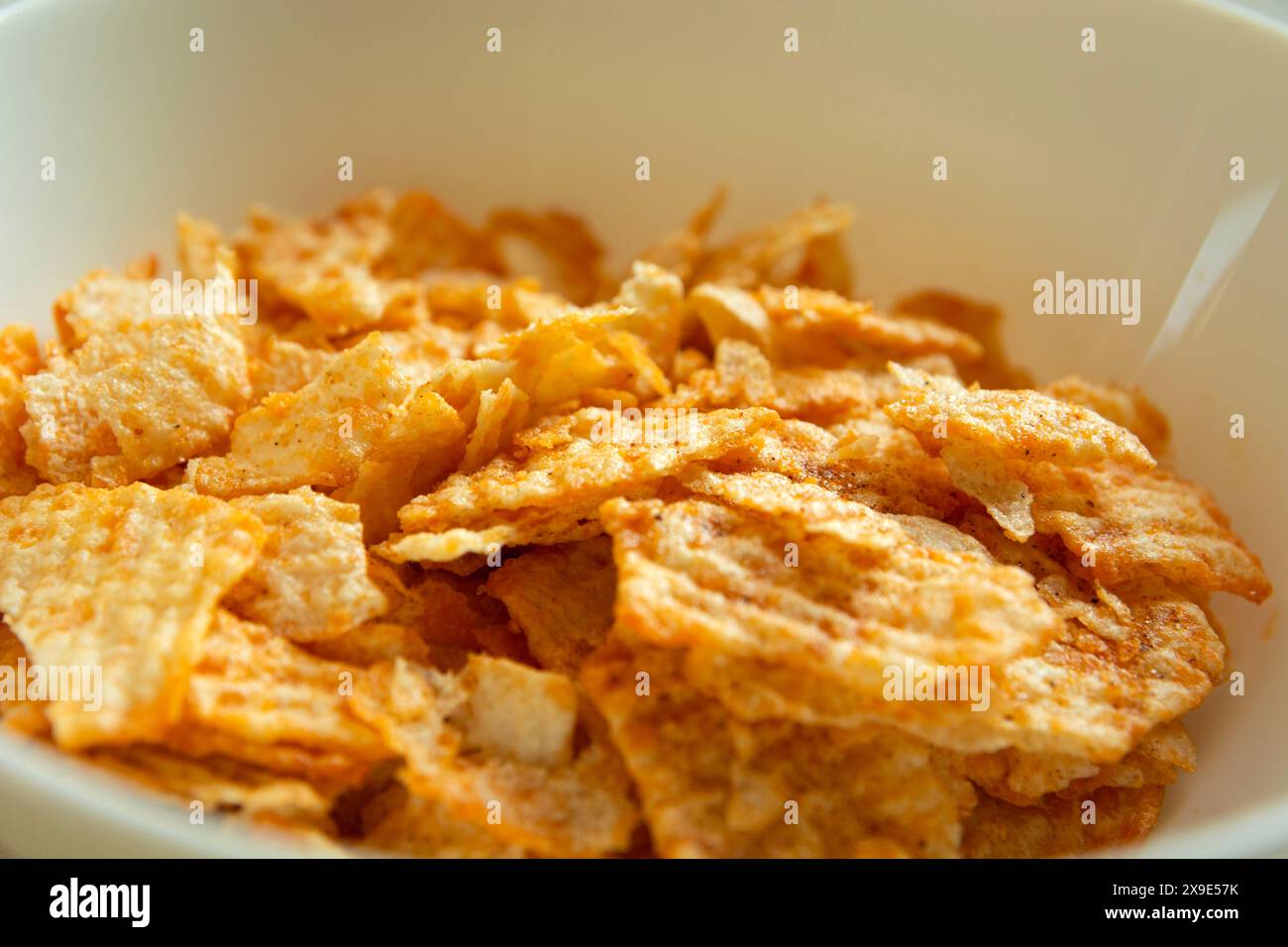 Close up of salty flavored chips in a white bowl Stock Photo