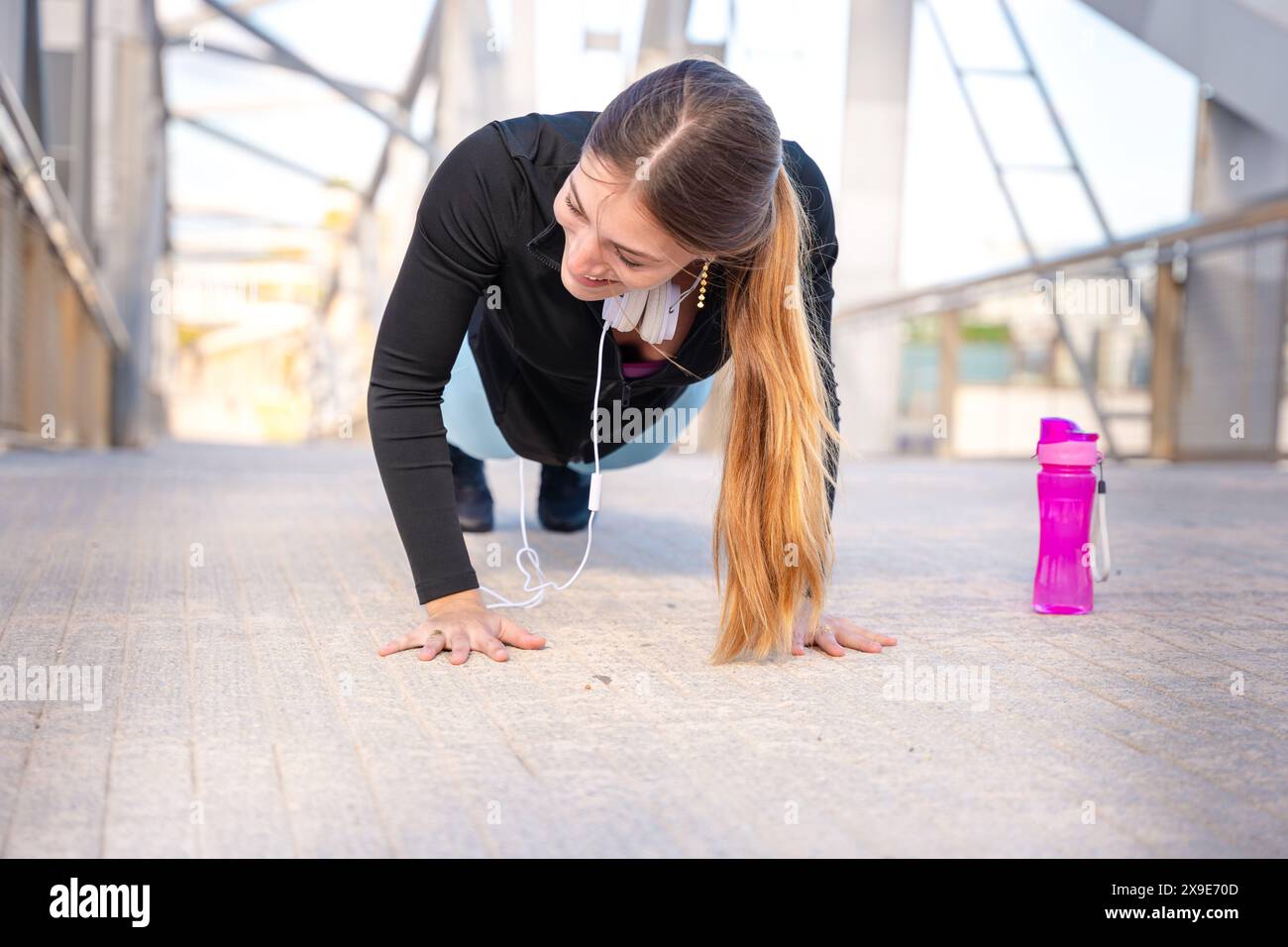 Active and fit young woman athlete doing push-ups outdoors. Stock Photo