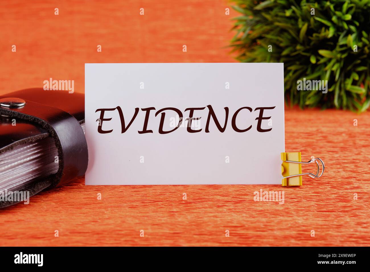 EVIDENCE text on a white card in front of an orange background with a ...