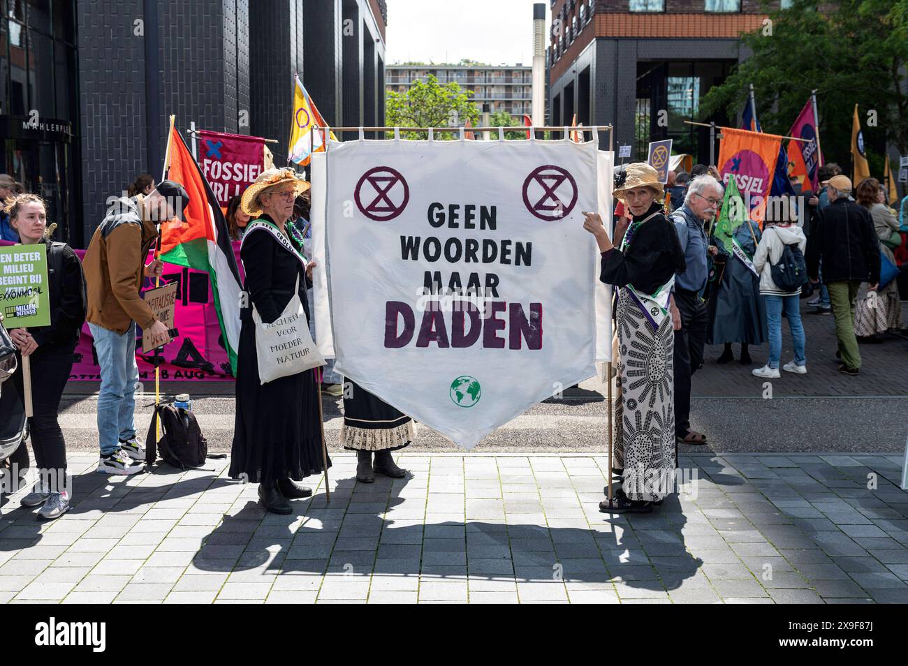 Amsterdam The Netherlands May 31st 2024 Klimaatmars. Climate March. In the Zuidas Amsterdam business district thousands march campaigning for a variety of environmental issues. XR Extinction rebellion ladies dressed in way such as the suffragettes with a banner Geen woorden maar daden. Not words but deeds. milieu, demo, demonstration, protest, mars, Stock Photo