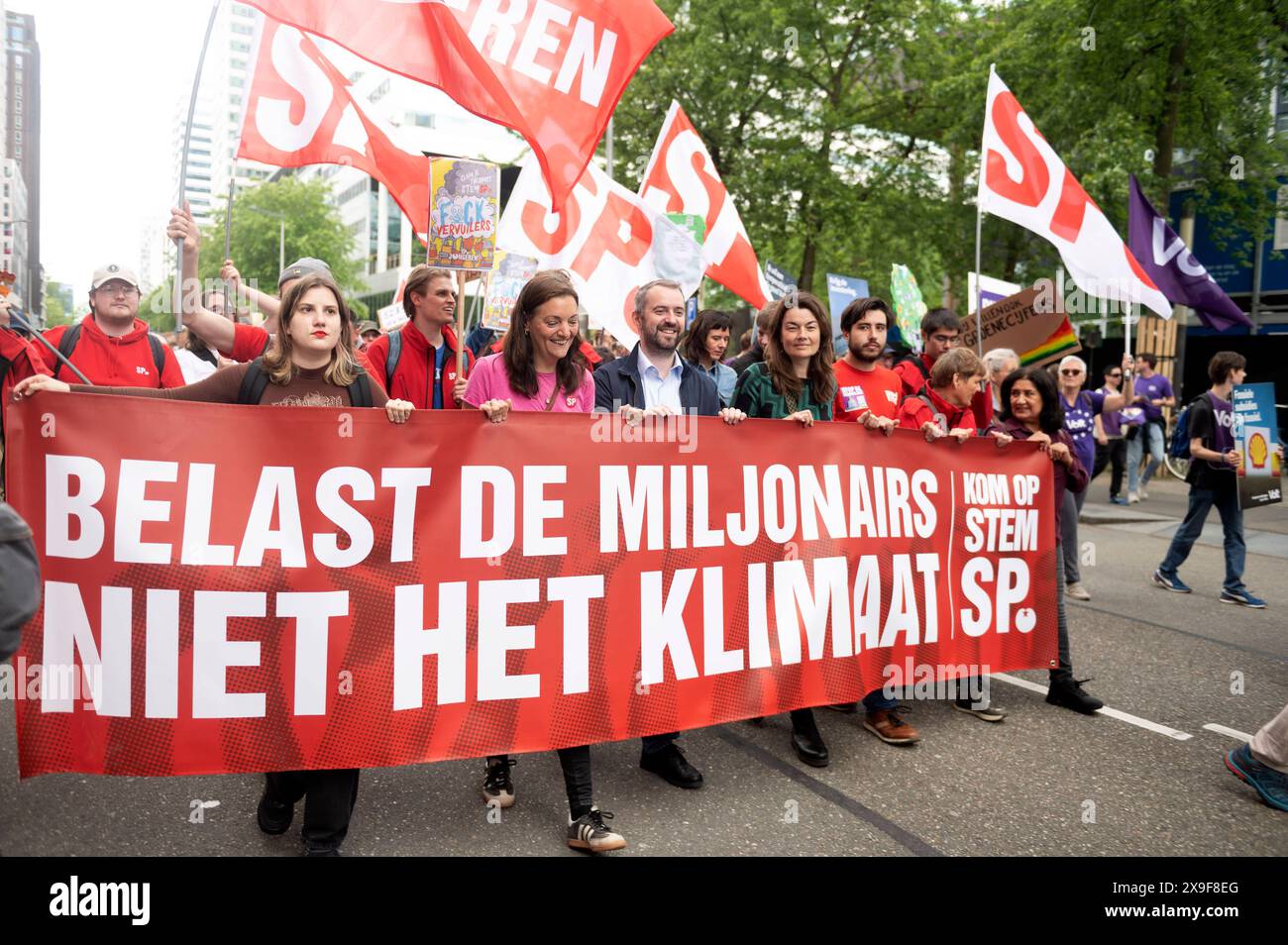 Amsterdam The Netherlands May 31st 2024 Klimaatmars. Climate March. In the Zuidas Amsterdam business district thousands march campaigning for a variety of environmental issues. Members of parliament for the SP, Sandra Beckerman, Jimmy Dijk and Sarah Dobbe with banner Belast de miljonairs niet de milieu, Tax the Millionaires not the environment. milieu, demo, demonstration, protest, mars, pvdd, Stock Photo