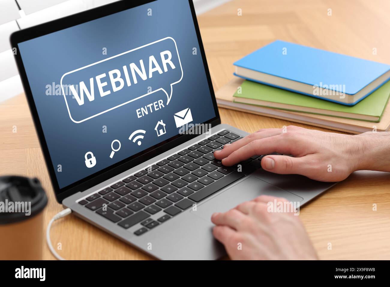 Webinar. Man using laptop at table, closeup Stock Photo