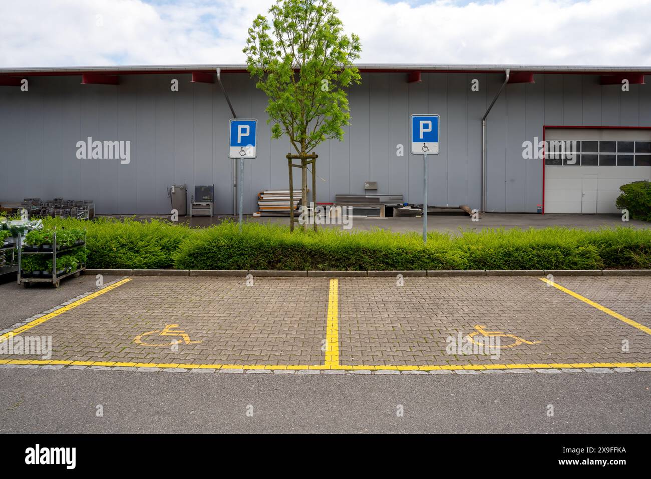 Two parking lots for handicapped people with blue signs to prevent unauthorized parking. Stock Photo