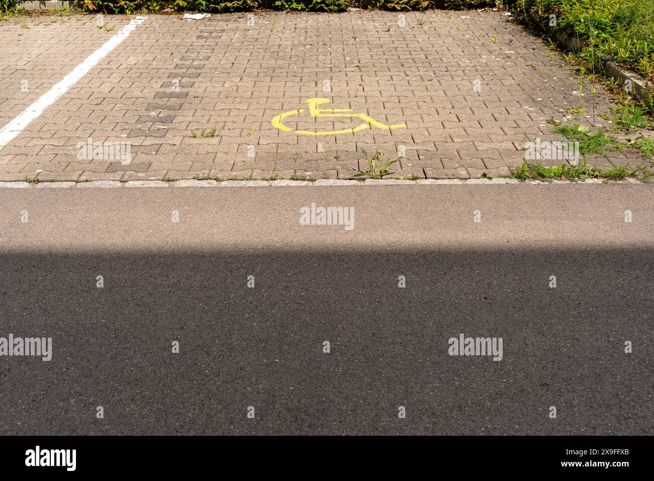 Parking space with wheelchair symbol. Shadow in the foreground. Parking only for handicapped people. Concept of social responsibility, caring, respect Stock Photo