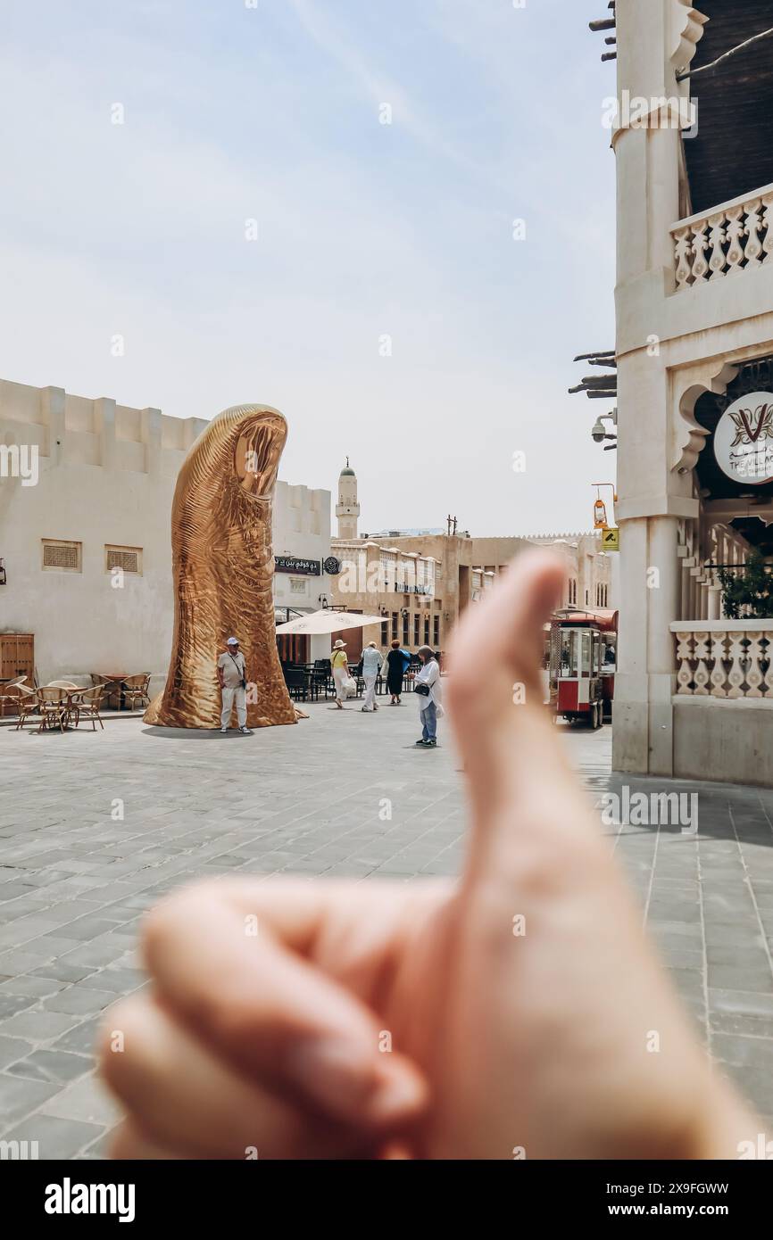 Doha, Qatar - 1 May 2024: The Golden Thumb Statue, an art piece by ...