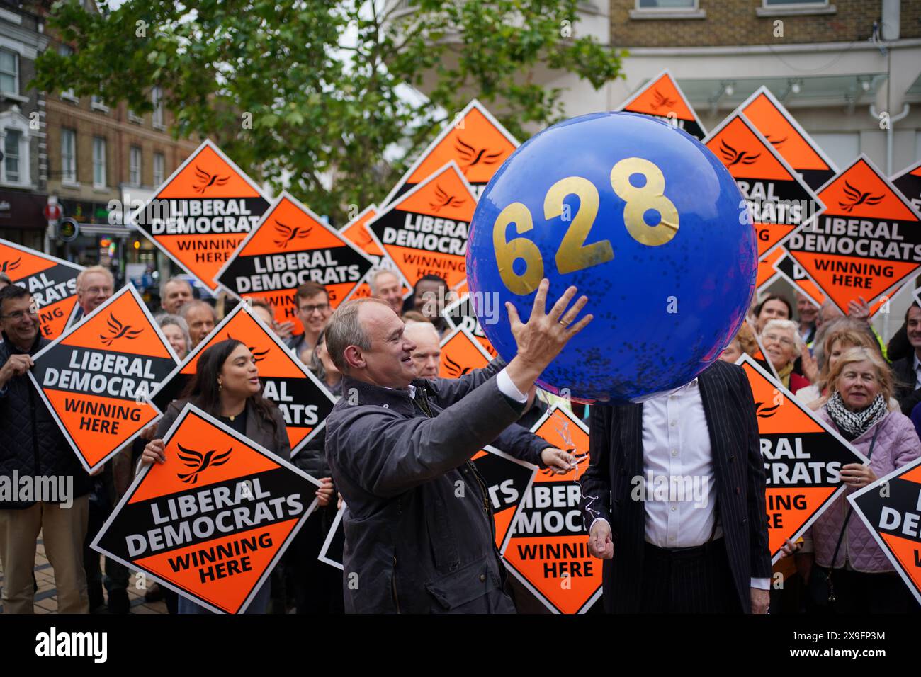 Liberal Democrats leader Sir Ed Davey holding a balloon, with a figure that represents the amount of votes the Liberal Democrat party lost by in the previous General Election, during a rally outside Morrison's supermarket in Wimbledon, while on the General Election campaign trail. Picture date: Friday May 31, 2024. Stock Photo