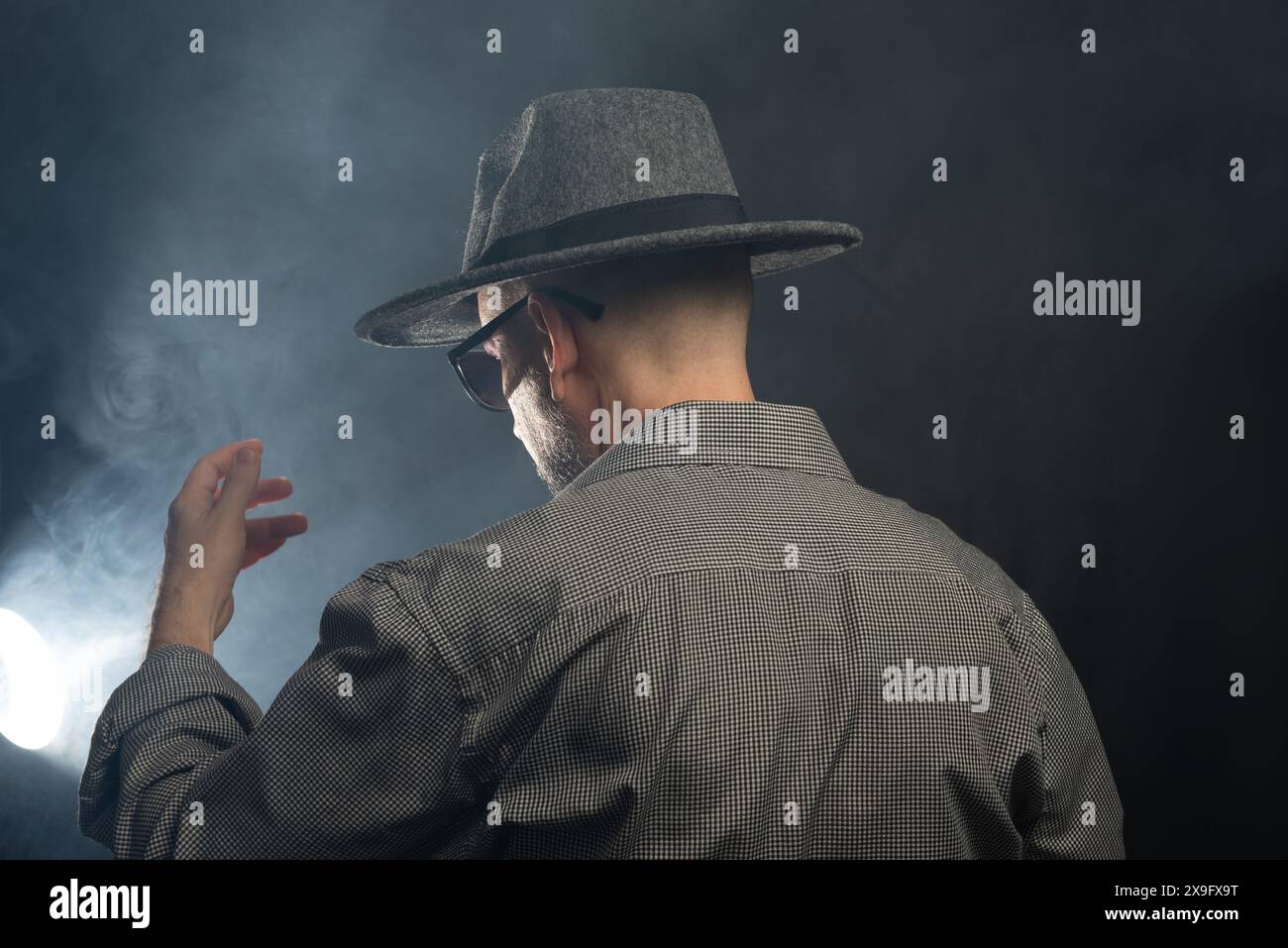 Portrait of a man with a beard and sunglasses and hat with his back to ...
