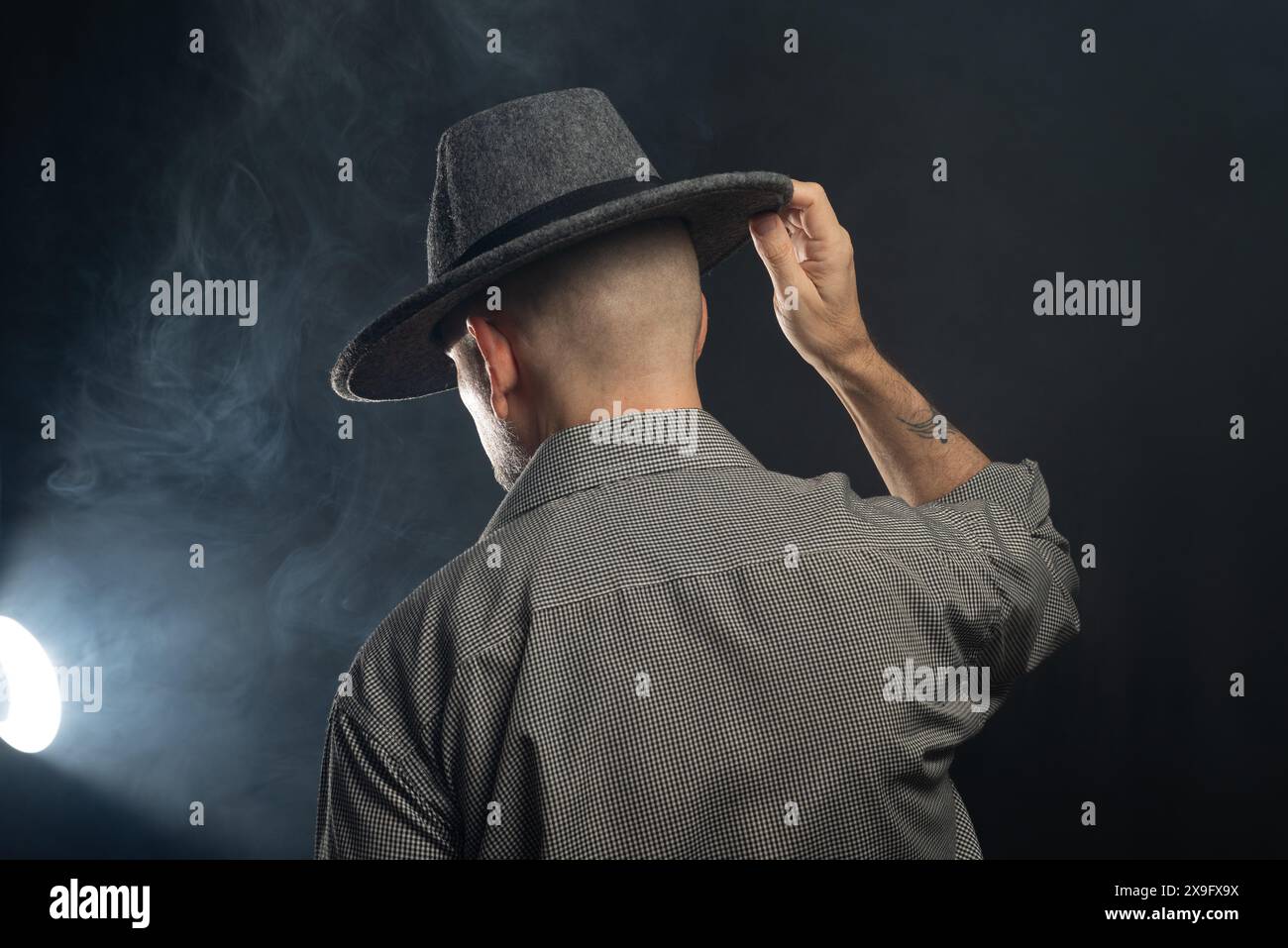 Portrait of a man with a beard and sunglasses and hat with his back to ...