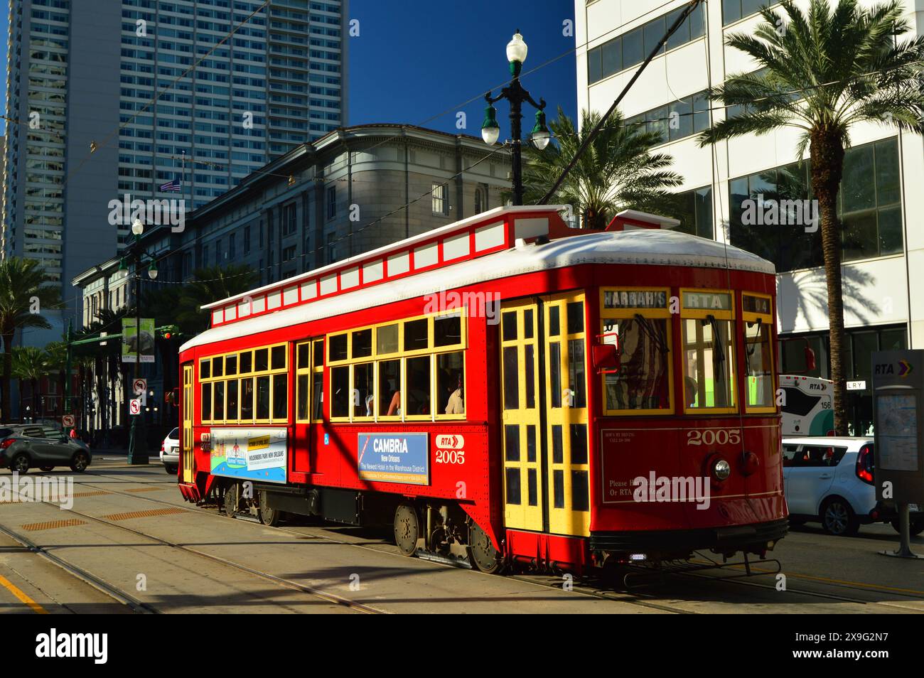 A red streetcar tram drives through the streets of downtown New Orleans carrying tourists and commuters to the French Quarter of New Orleans Stock Photo
